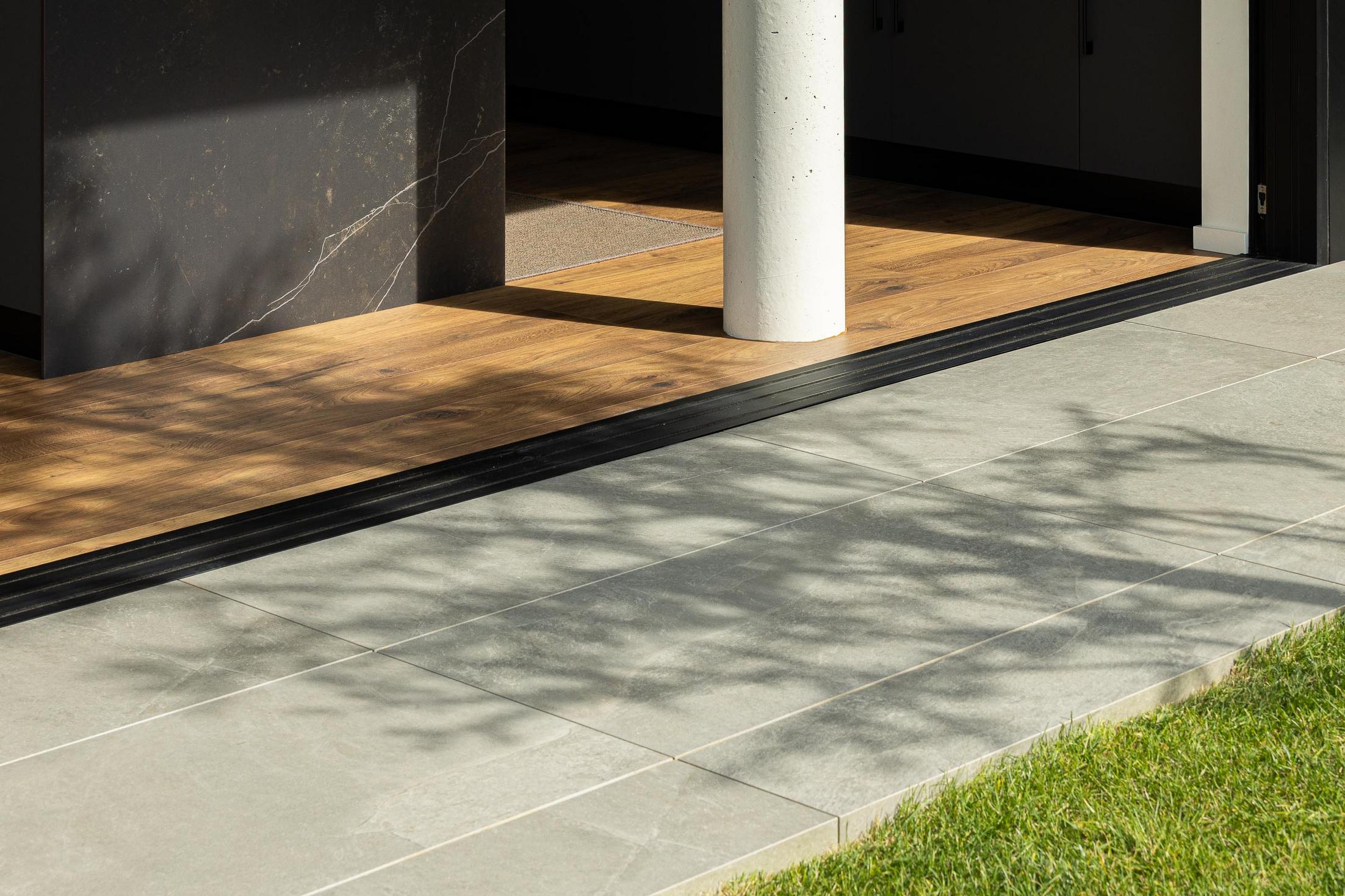 Exterior: Alpendre com cozinha minimalista em tons escuros, mesa de jantar e cortinas brancas. — CASA A arquitetura L2C Arquitetura em Braga