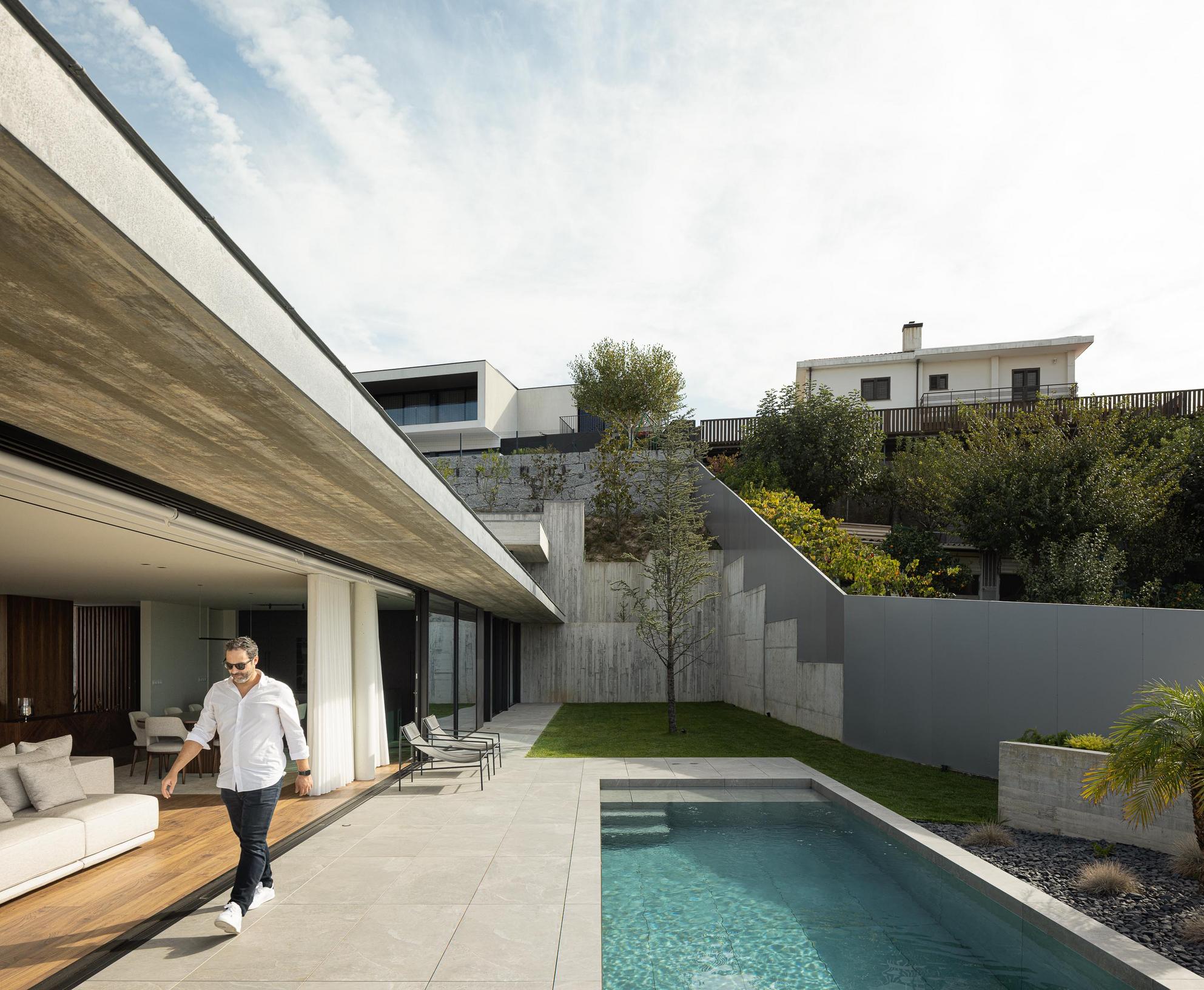Exterior: Detalhe da transição entre o pavimento cerâmico do alpendre e o soalho em madeira da cozinha. — CASA A arquitetura L2C Arquitetura em Braga