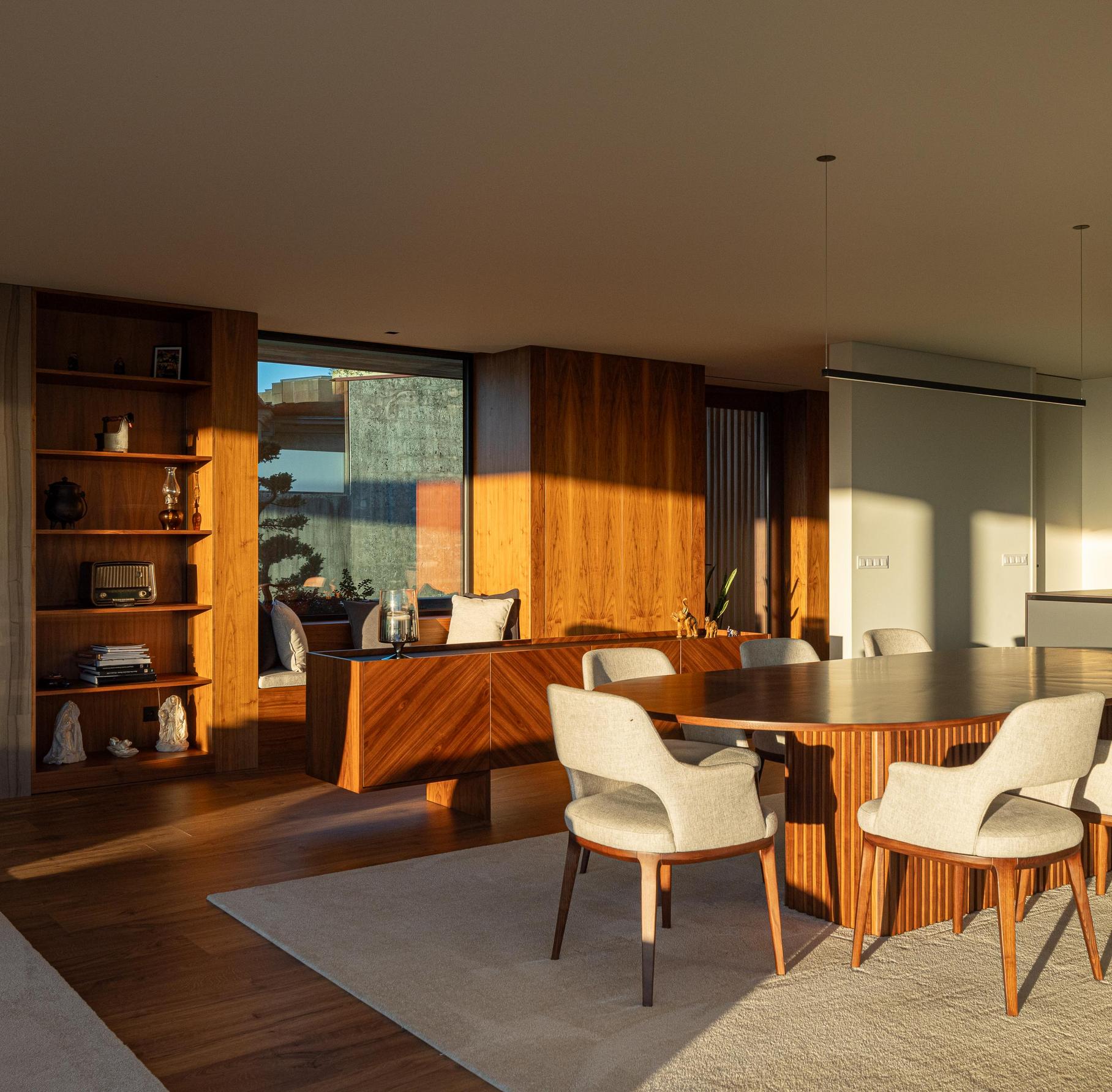 Sala de estar/Jantar: Espaço amplo com sofás, mesa de jantar e vista panorâmica da paisagem. — CASA A arquitetura L2C Arquitetura em Braga