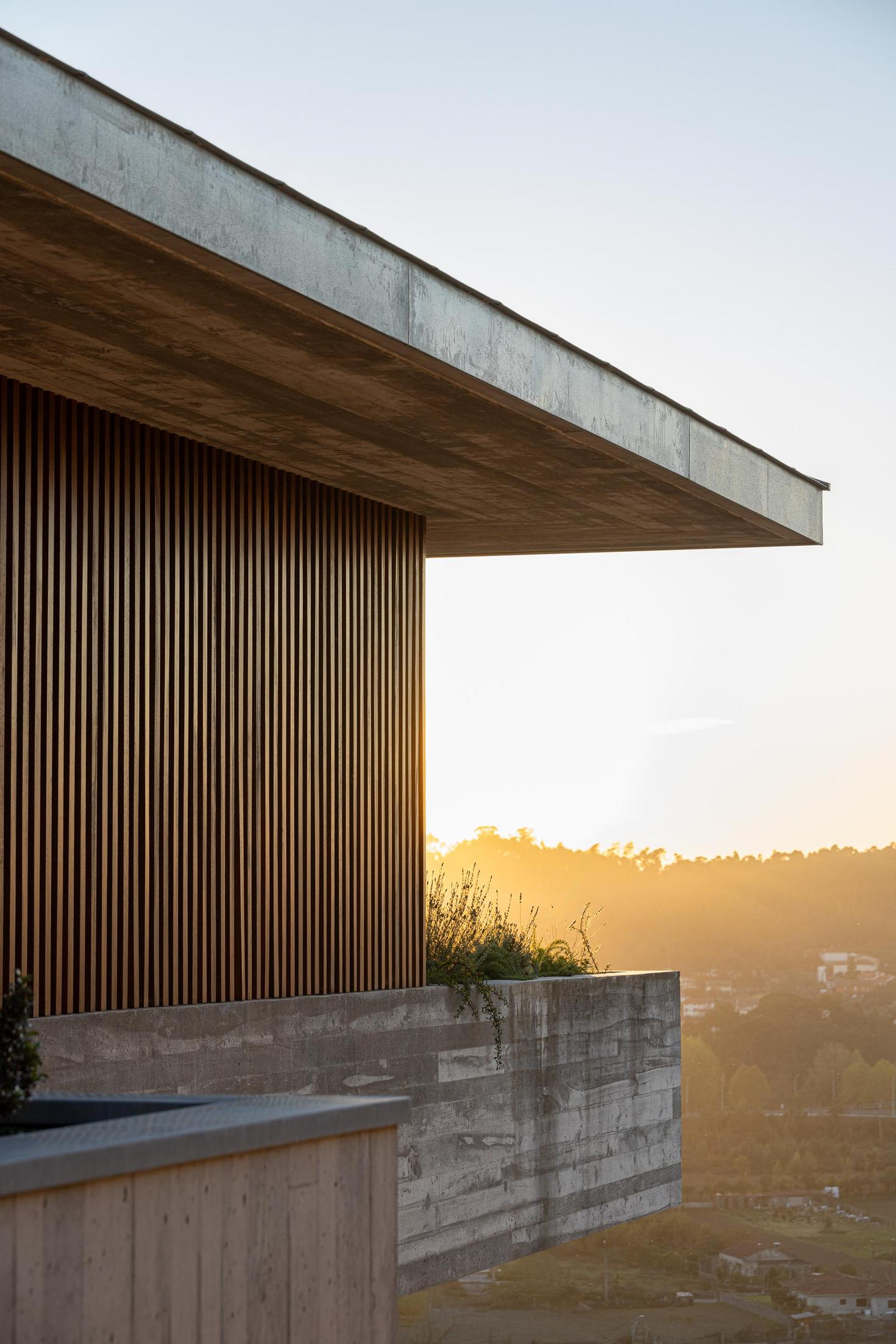 Entrada: Porta de entrada em ripas de madeira e fachada em betão aparente. — CASA A arquitetura L2C Arquitetura em Braga