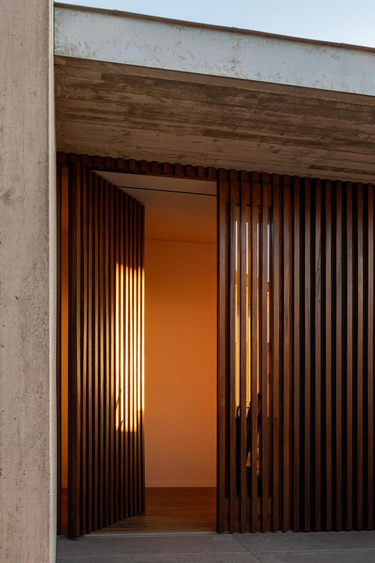 Exterior: Detalhe da fachada com ripas de madeira e floreira em betão aparente. — CASA A arquitetura L2C Arquitetura em Braga