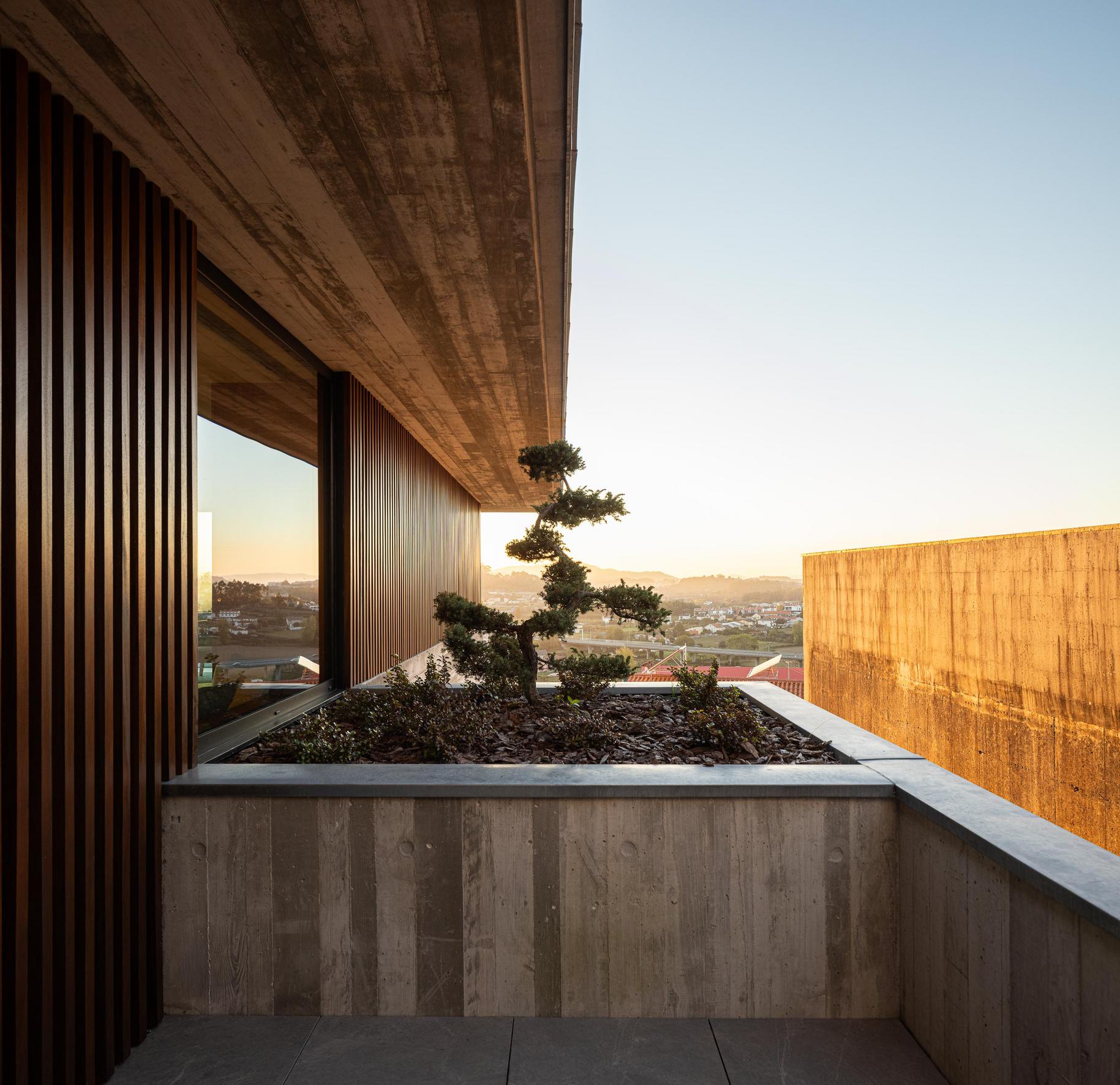 Exterior: Alpendre com piscina ao pôr do sol, sofás e mesa de jantar. — CASA A arquitetura L2C Arquitetura em Braga