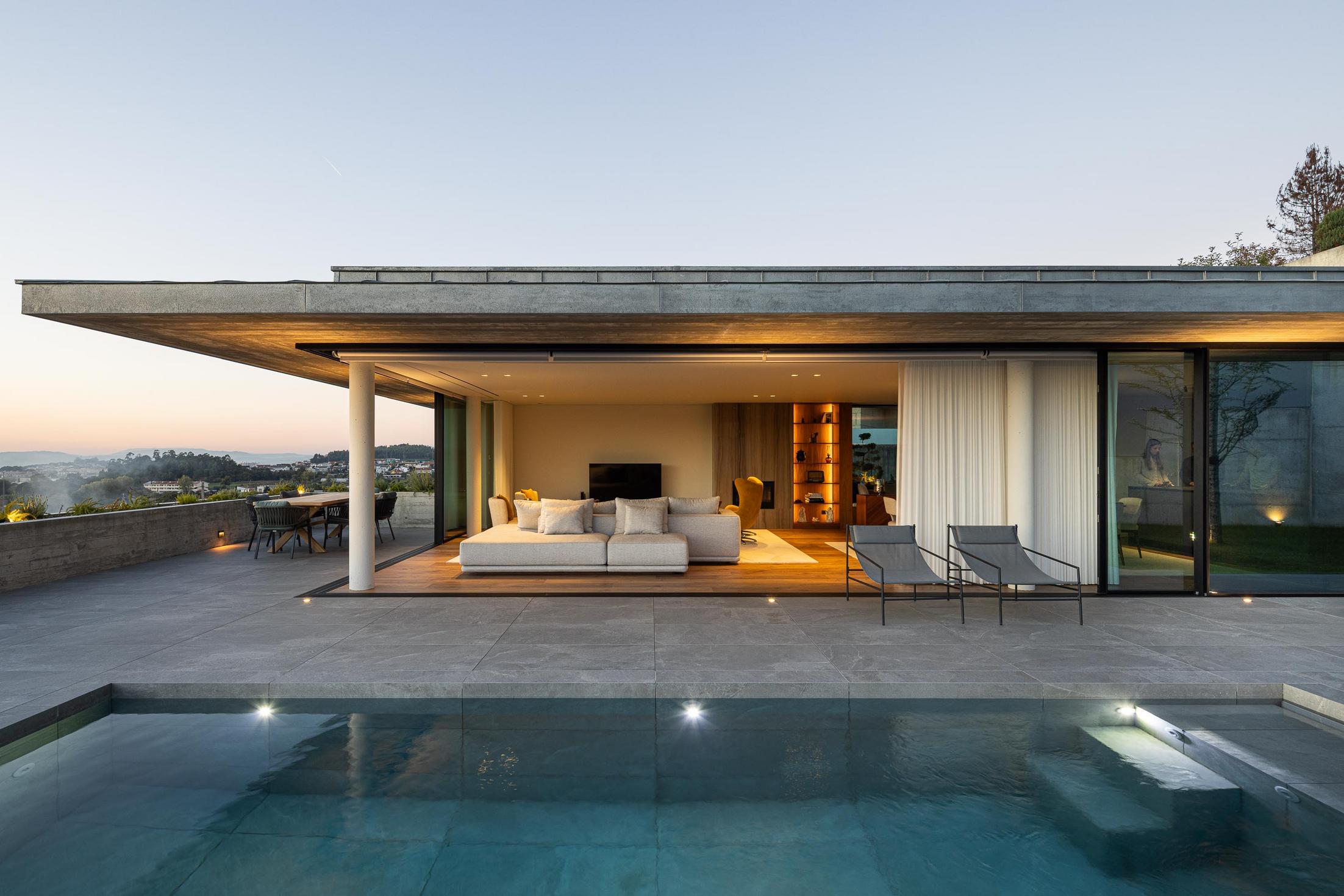 Exterior: Alpendre com vista para a paisagem ao entardecer e iluminação embutida. — CASA A arquitetura L2C Arquitetura em Braga