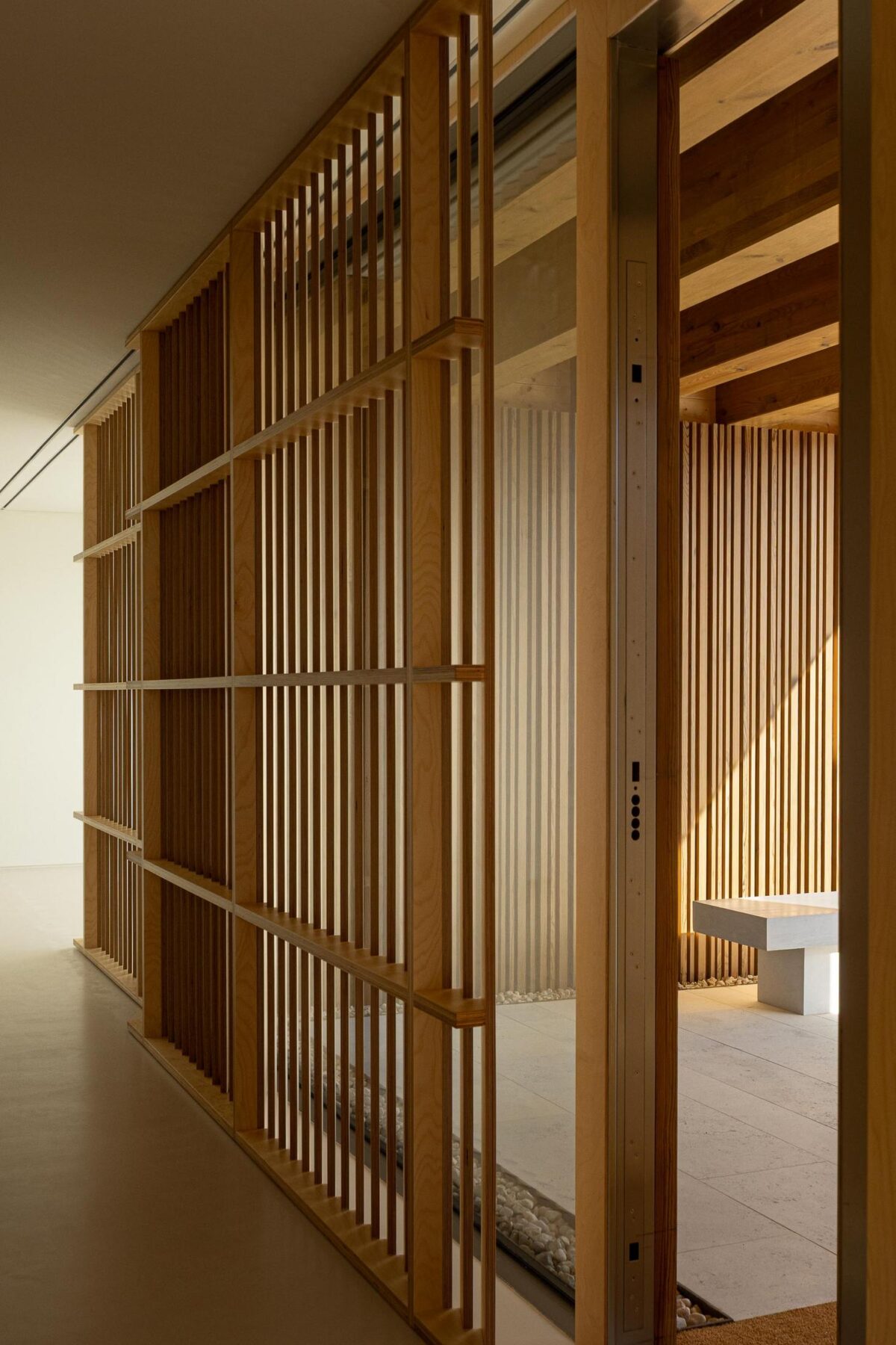 Corredor: Vista do interior com divisórias de madeira e porta de correr, pavimento claro. — WEST CLIFFS D45 arquitetura ARX Portugal - Arquitectos em Óbidos