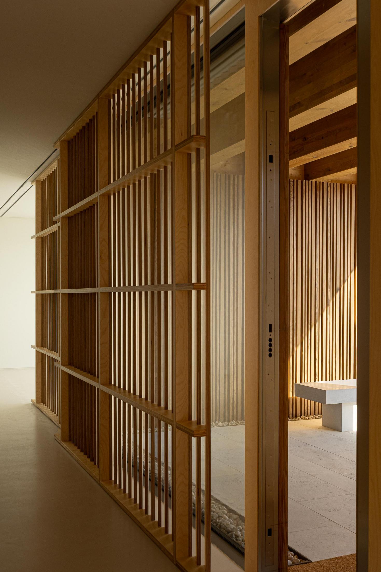 Corredor: Vista do interior com divisórias de madeira e porta de correr, pavimento claro. — WEST CLIFFS D45 arquitetura ARX Portugal - Arquitectos em Óbidos