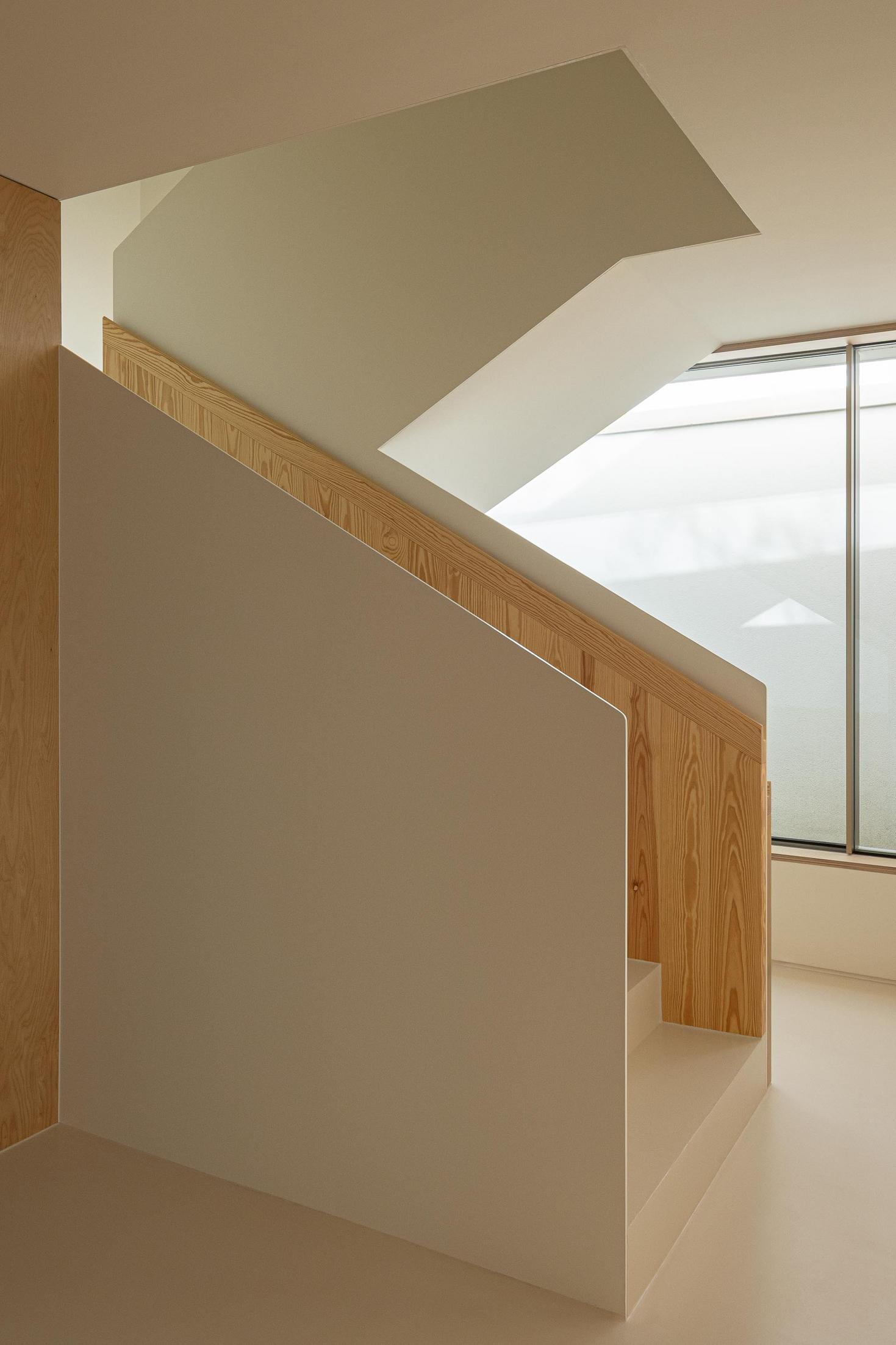 Escadaria: Detalhe da escadaria com corrimão em madeira e parede branca, pavimento claro. — WEST CLIFFS D45 arquitetura ARX Portugal - Arquitectos em Óbidos