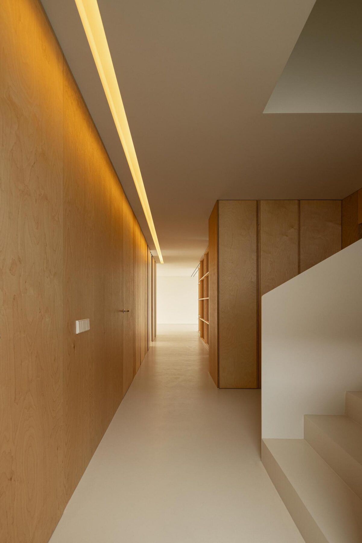 Corredor: Corredor com armários em madeira, iluminação linear e acesso à escadaria. — WEST CLIFFS D45 arquitetura ARX Portugal - Arquitectos em Óbidos