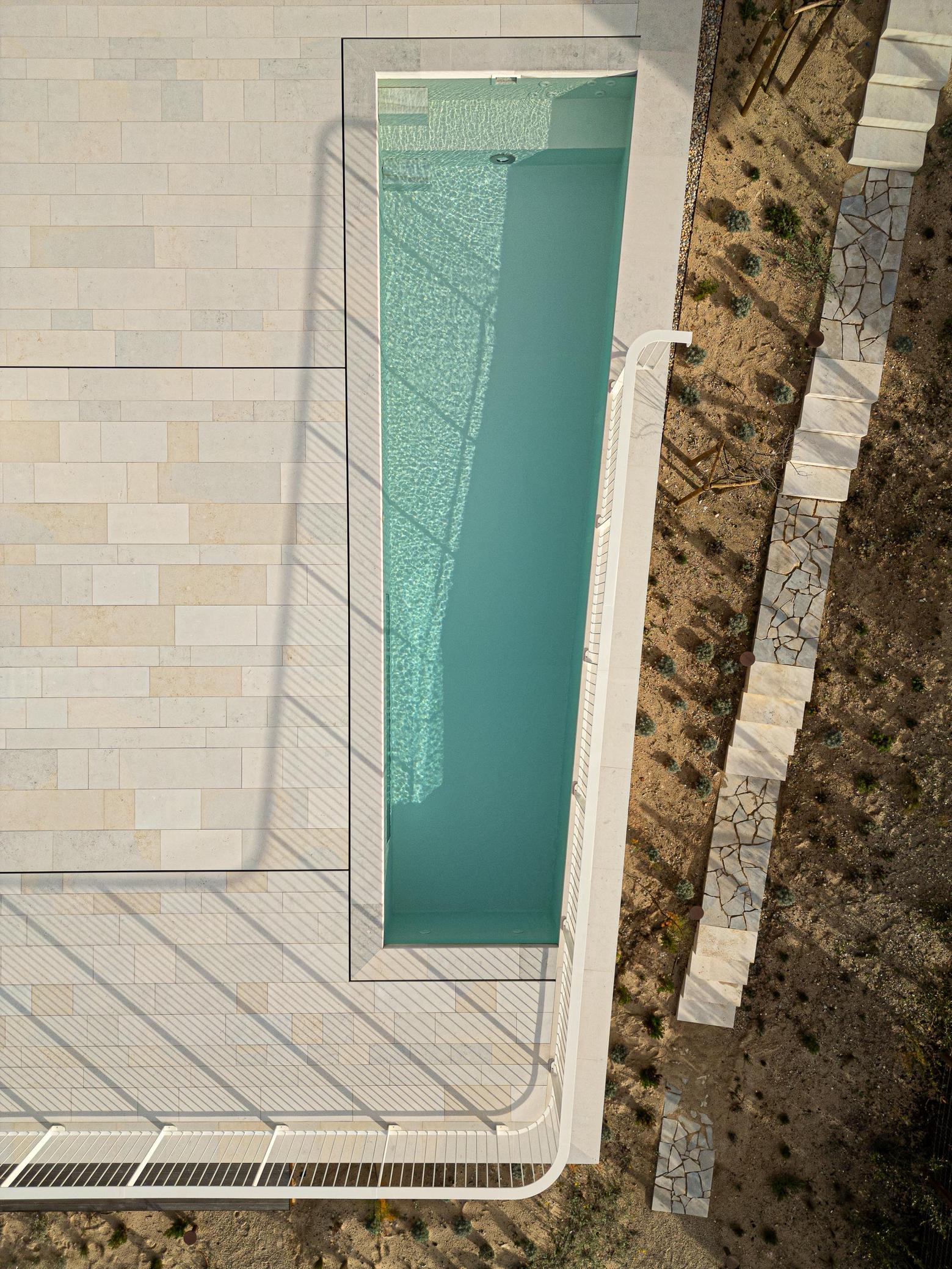 Piscina: Vista aérea da piscina retangular com pavimento em pedra e jardim. — WEST CLIFFS D45 arquitetura ARX Portugal - Arquitectos em Óbidos