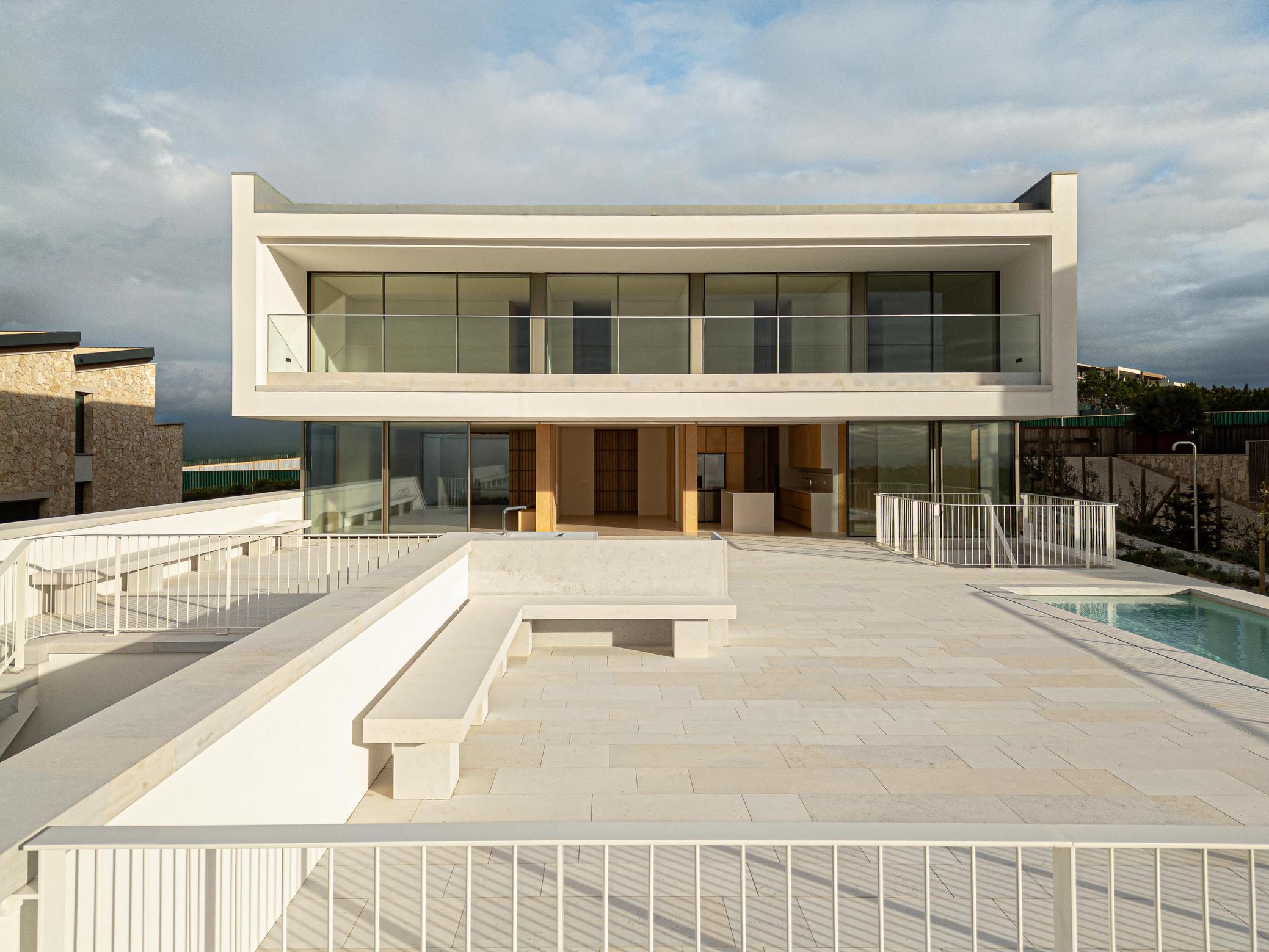 Fachada posterior: Vista da fachada posterior com terraço, piscina e mobiliário exterior. — WEST CLIFFS D45 arquitetura ARX Portugal - Arquitectos em Óbidos