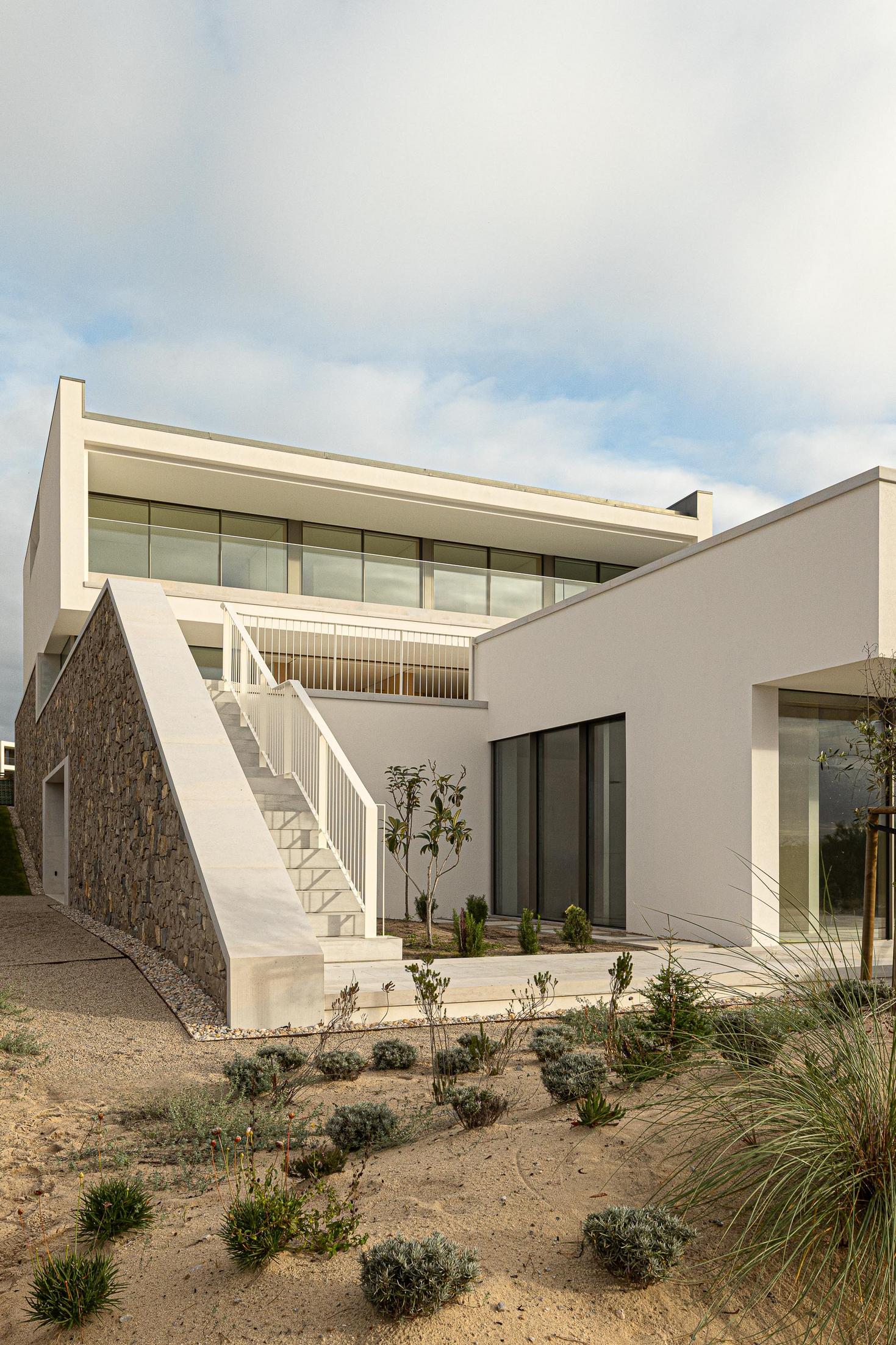 Jardim: Vista da casa com escadaria exterior, jardim e fachada em pedra rústica. — WEST CLIFFS D45 arquitetura ARX Portugal - Arquitectos em Óbidos
