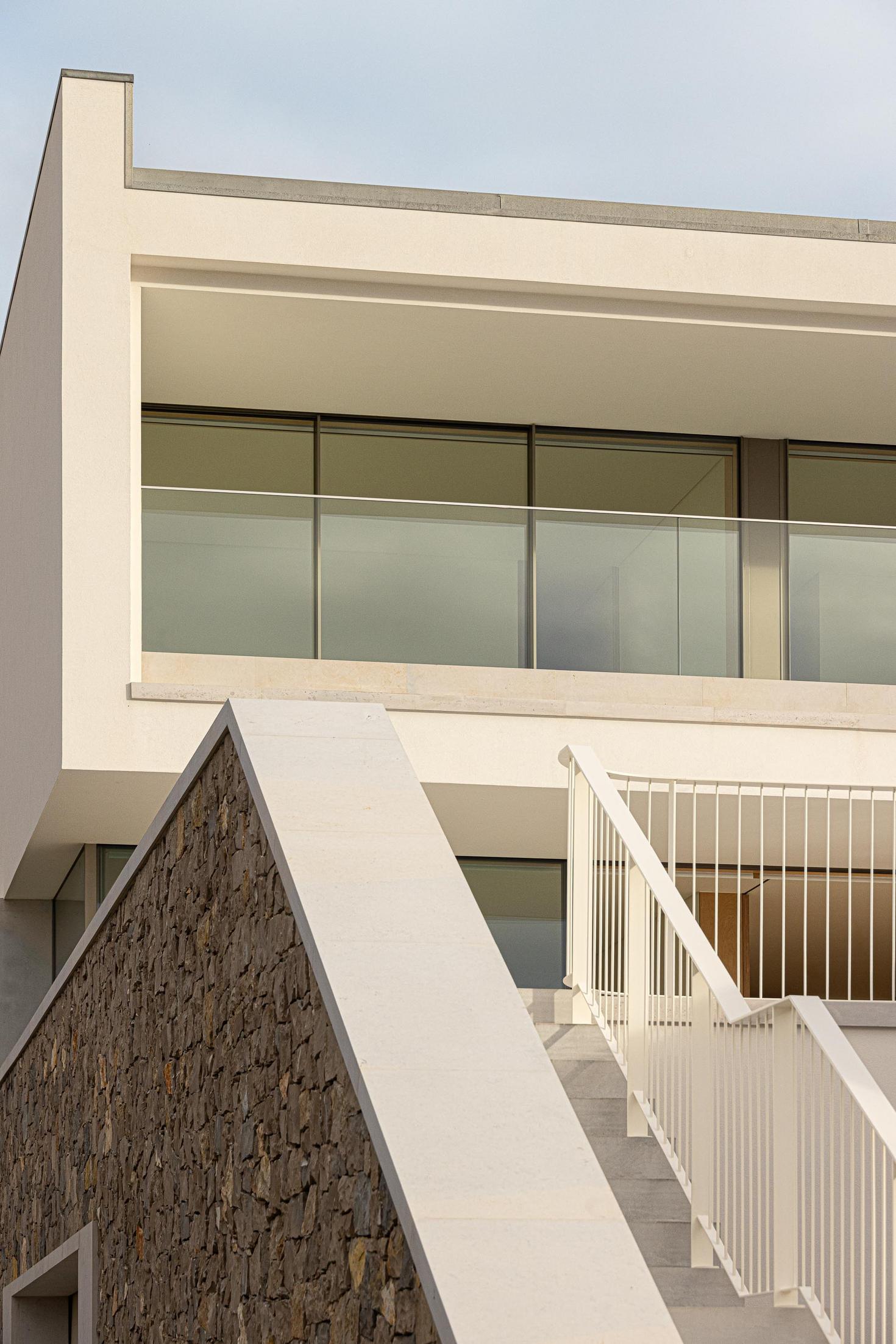 Fachada lateral: Detalhe da fachada com escadaria exterior e varanda envidraçada. — WEST CLIFFS D45 arquitetura ARX Portugal - Arquitectos em Óbidos