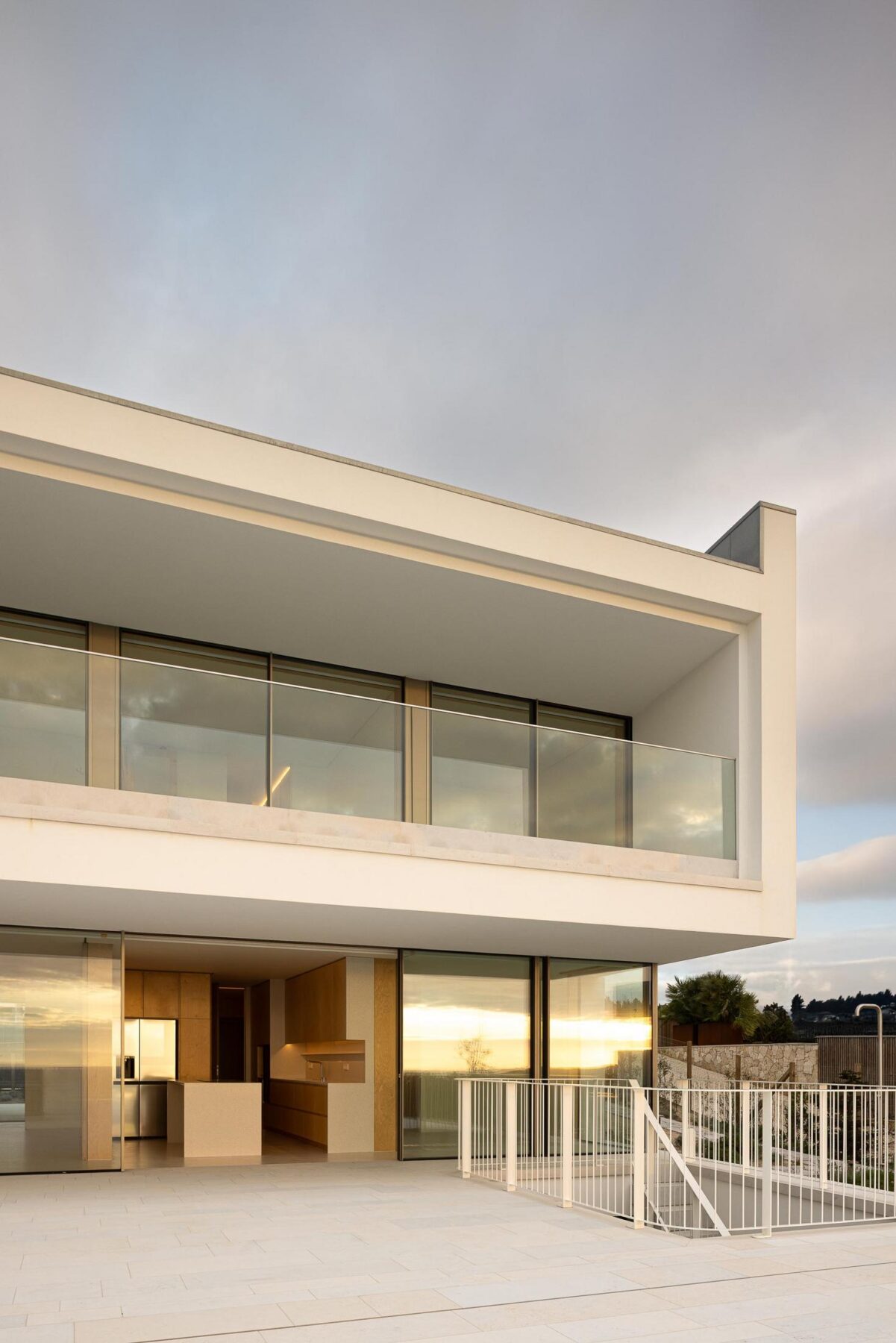 Fachada lateral: Detalhe da fachada com varanda envidraçada e terraço com piscina. — WEST CLIFFS D45 arquitetura ARX Portugal - Arquitectos em Óbidos
