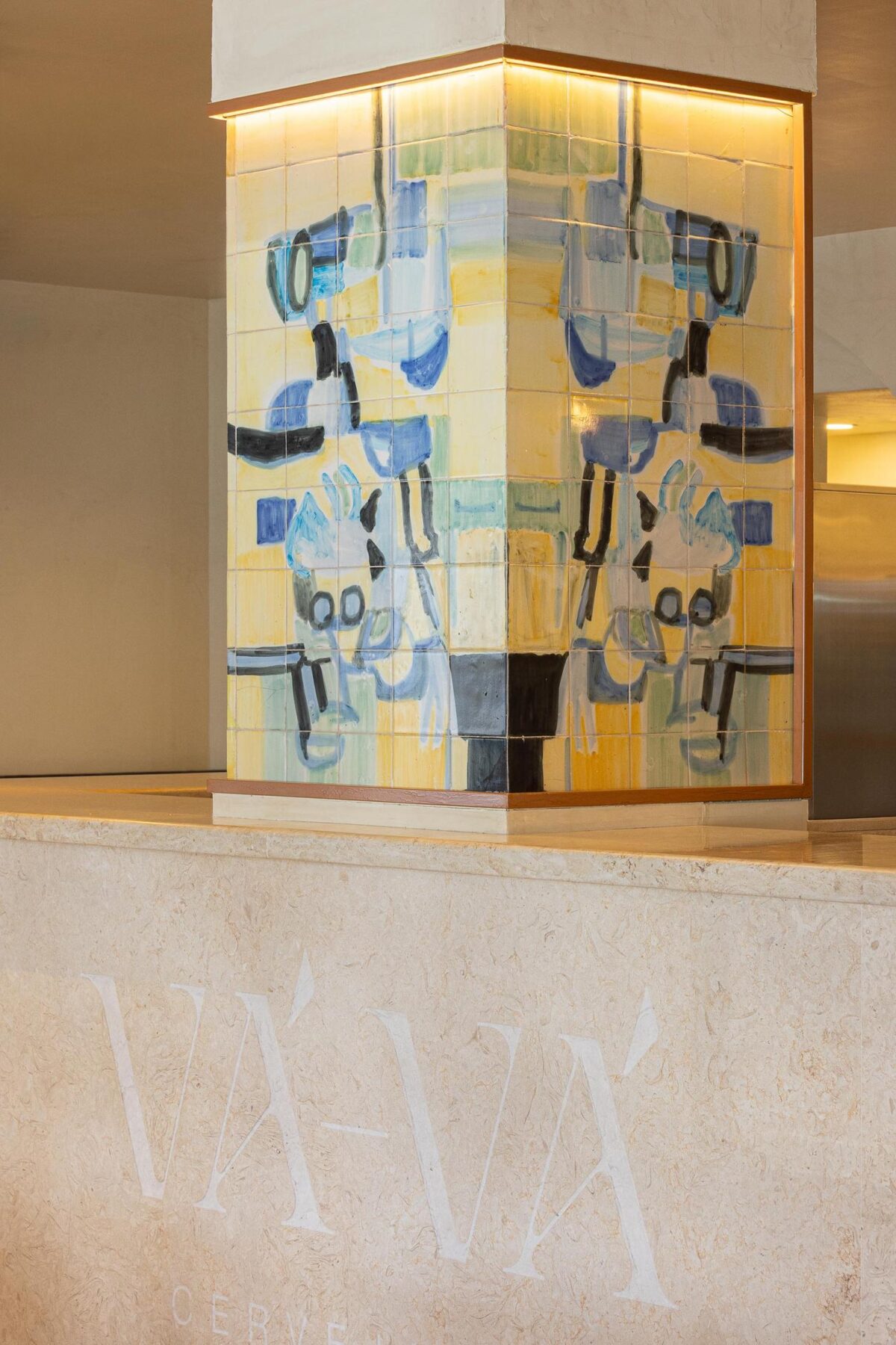 Balcão: Painel de azulejos com iluminação embutida sobre o balcão em pedra clara. — Cervejaria Vává - Requalificação arquitetura Rethorica Studio em Lisboa