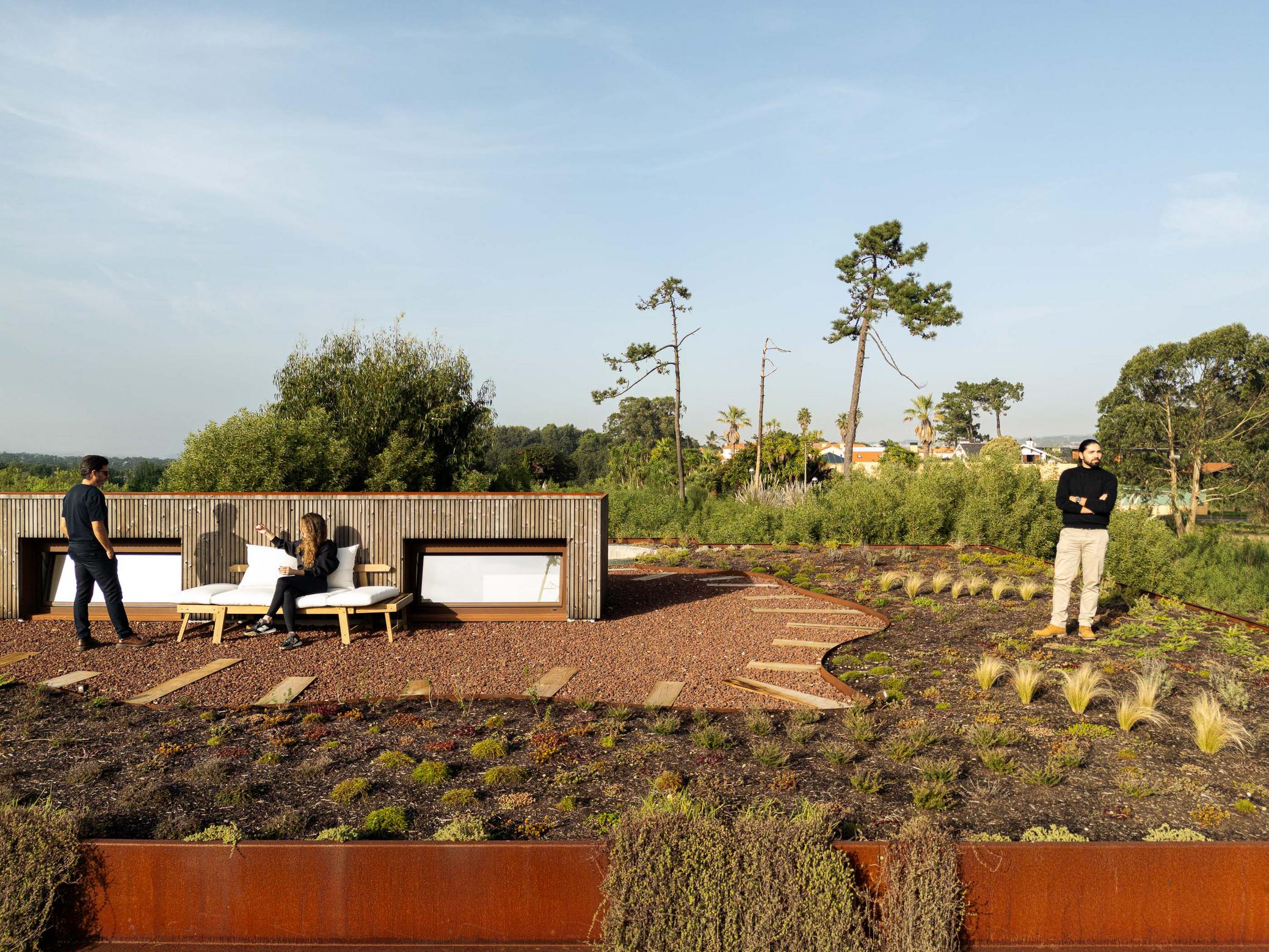 Telhado ajardinado com área de estar, mobiliário de exterior e vista panorâmica da paisagem. — Mimosa House arquitetura Pedro Henrique Arquitecto em Esmoriz