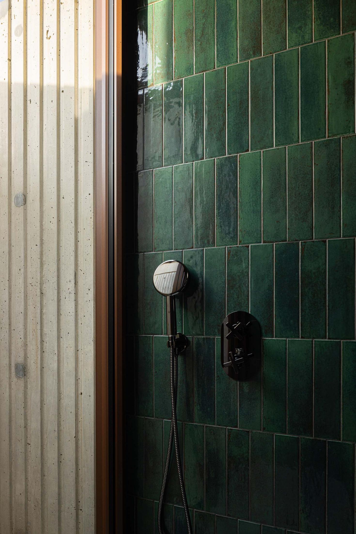 Detalhe do chuveiro com revestimento em azulejo verde e parede em betão aparente. — Mimosa House arquitetura Pedro Henrique Arquitecto em Esmoriz