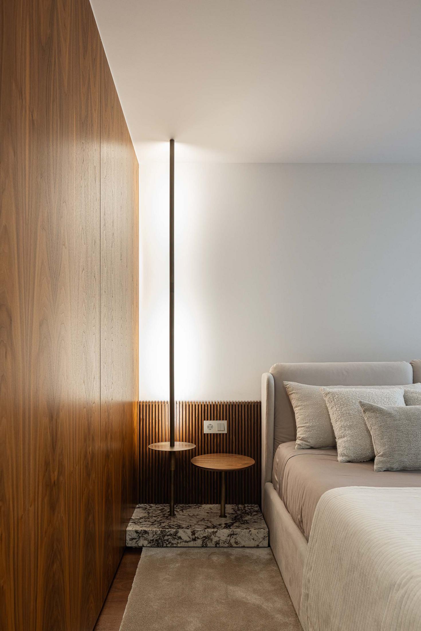 Detalhe do quarto com candeeiro de pé, mesas de cabeceira e revestimento em madeira. — Mimosa House arquitetura Pedro Henrique Arquitecto em Esmoriz