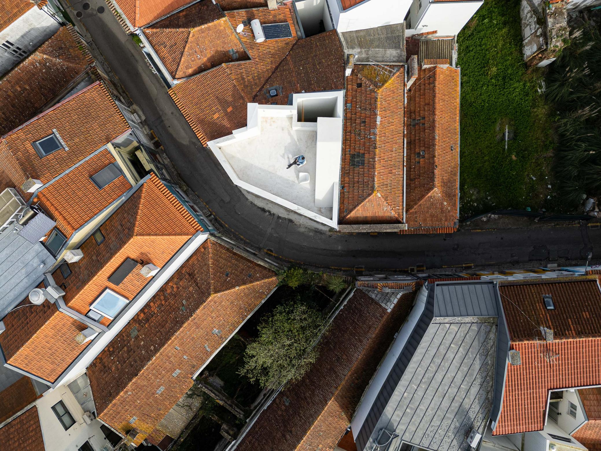 Cobertura da moradia branca, com terraço e pátio vertical. Inserida em malha urbana de telhados de barro — Beira Mar II arquitectura Paulo Martins fotografia Ivo Tavares