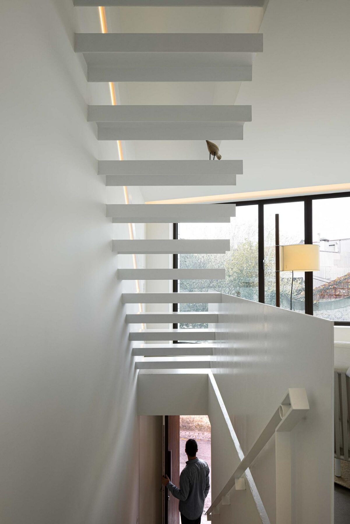 Escadas: Escadas flutuantes brancas com iluminação embutida e vista para o exterior. — Beira Mar II arquitetura Paulo Martins Arquitectura e Design em Aveiro