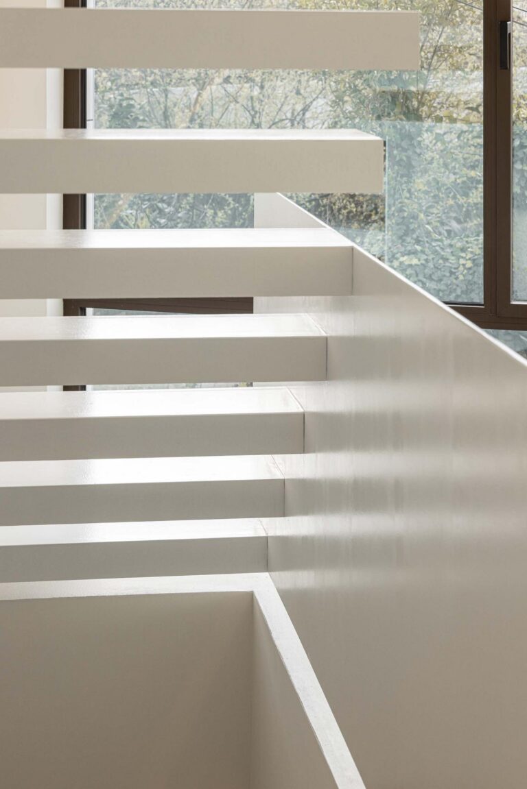 Escadas: Detalhe das escadas flutuantes brancas com vista para o exterior através da janela. — Beira Mar II arquitetura Paulo Martins Arquitectura e Design em Aveiro