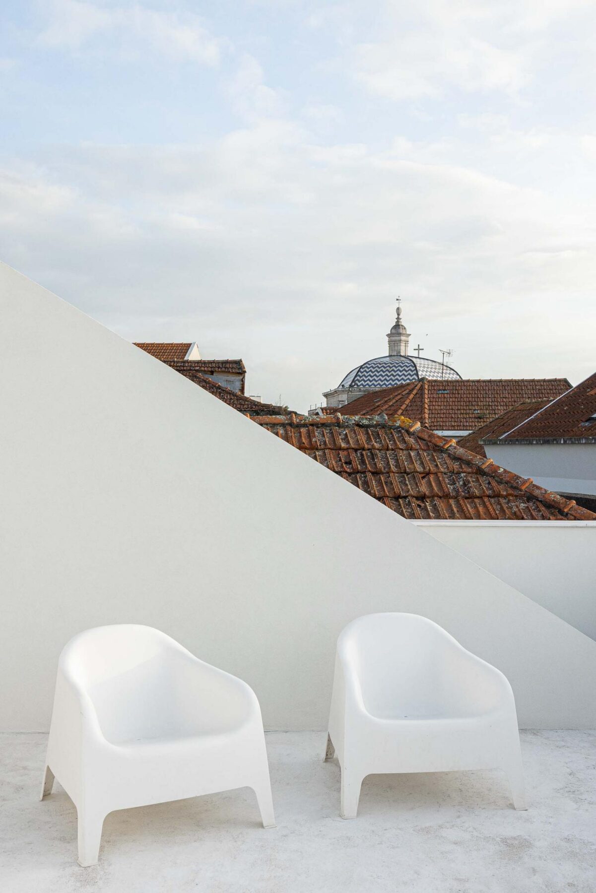 Terraço: Terraço branco com cadeiras de plástico e vista para os telhados de Aveiro. — Beira Mar II arquitetura Paulo Martins Arquitectura e Design em Aveiro