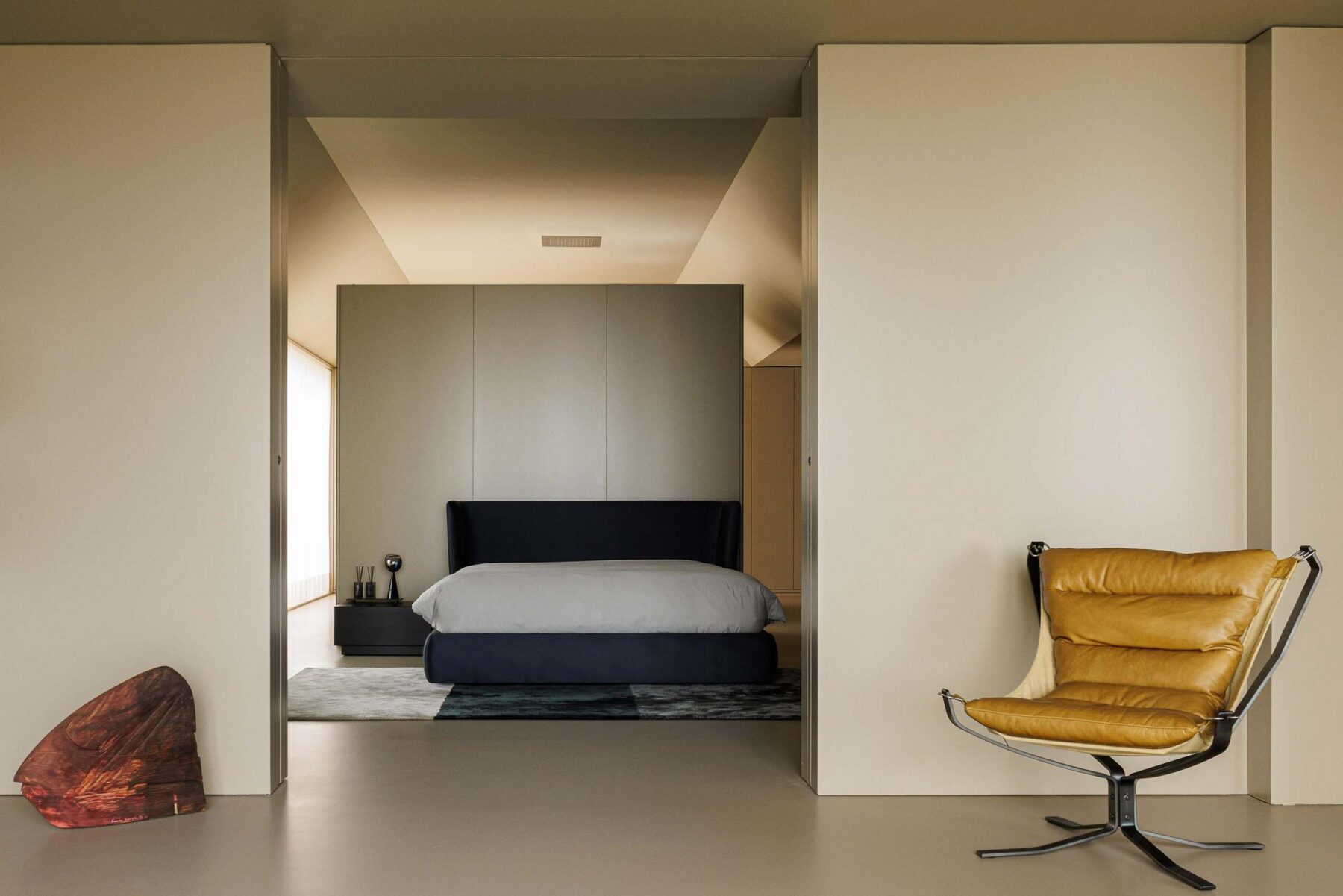 Quarto: Quarto minimalista com cama azul, cadeira de couro e pavimento cinza. — Assembleia da Granja arquitetura Lousinha Arquitectos em Vila Nova de Gaia