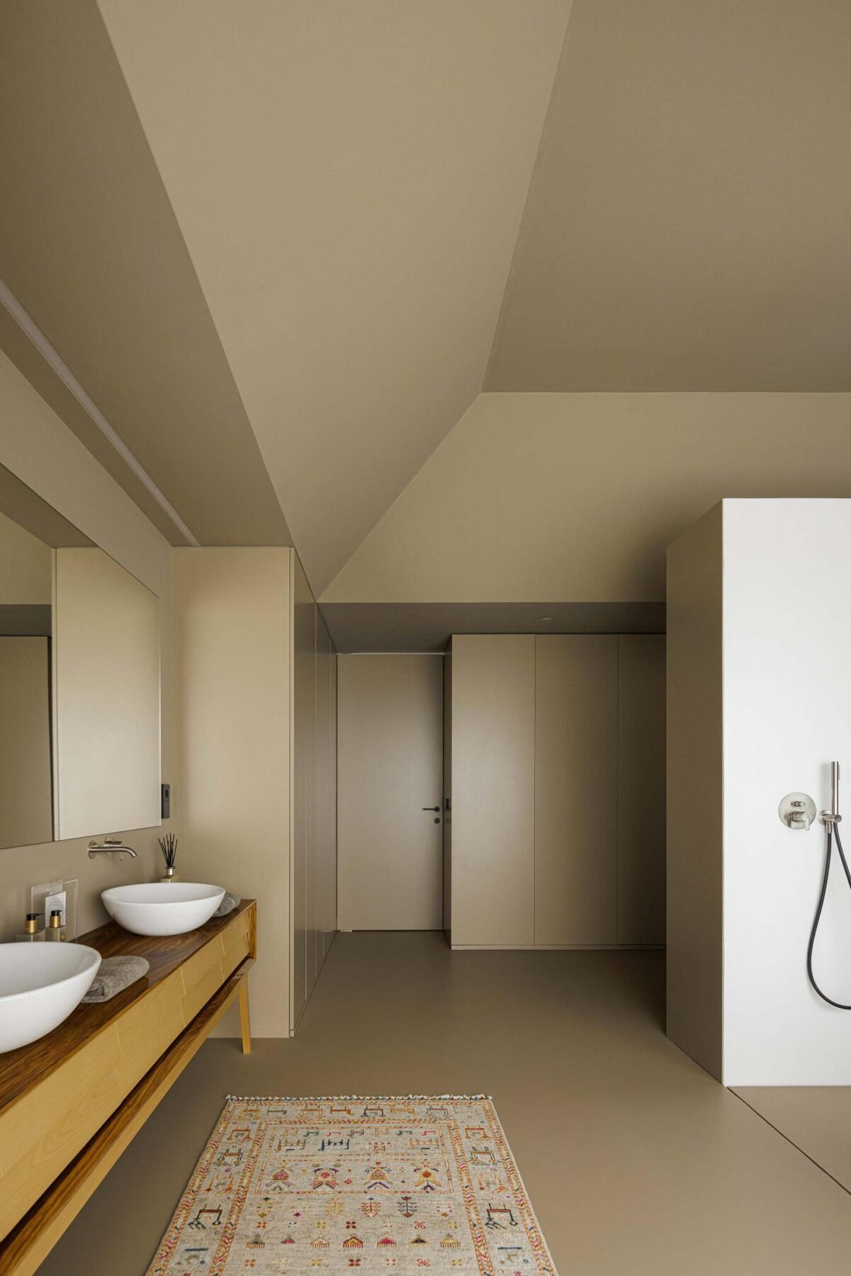 Casa de banho: Casa de banho com lavatório duplo, cabine de duche e armários embutidos. — Assembleia da Granja arquitetura Lousinha Arquitectos em Vila Nova de Gaia