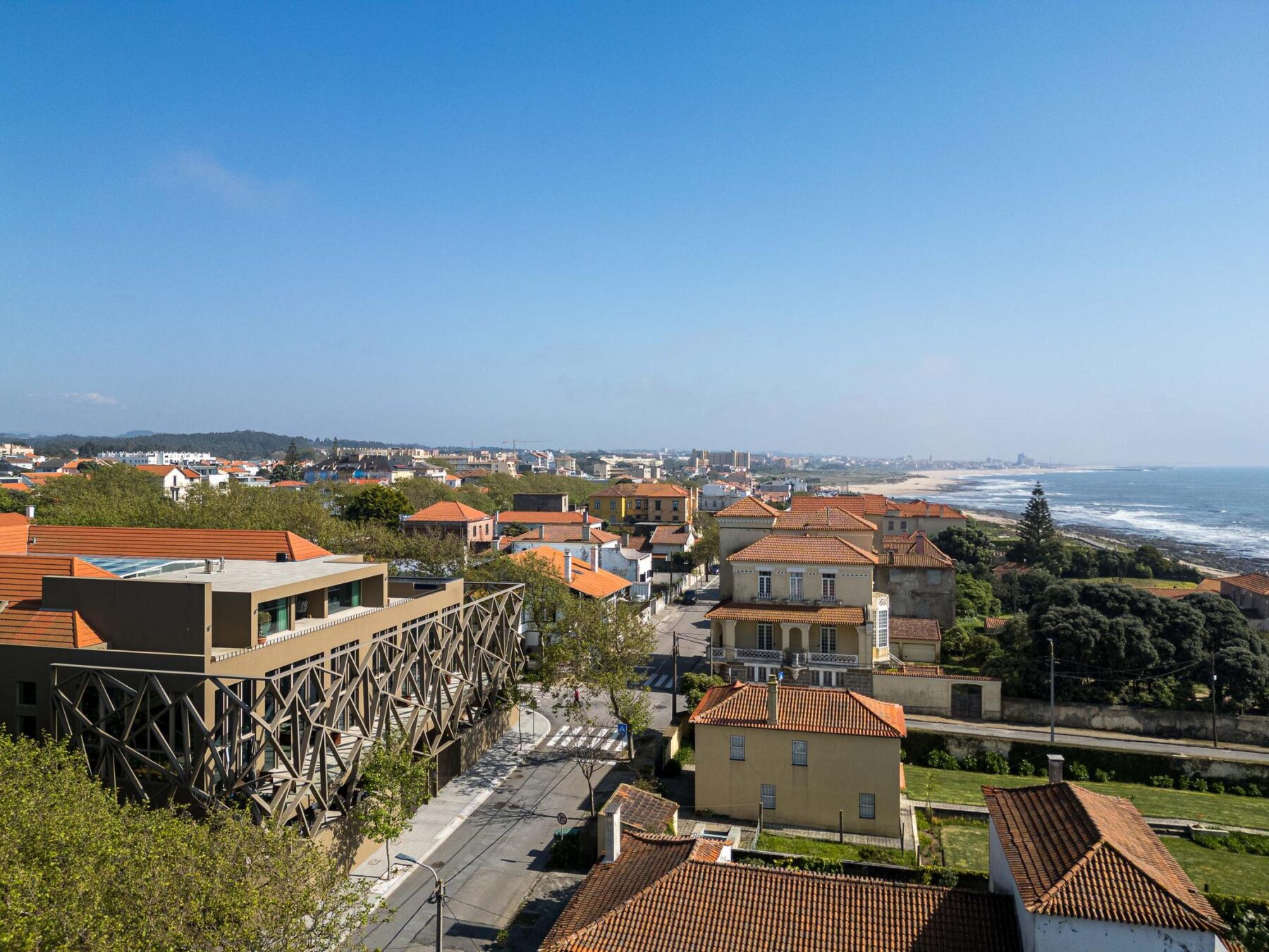 Exterior: Vista panorâmica do edifício com estrutura metálica, integrado na paisagem urbana. — Assembleia da Granja arquitetura Lousinha Arquitectos em Vila Nova de Gaia