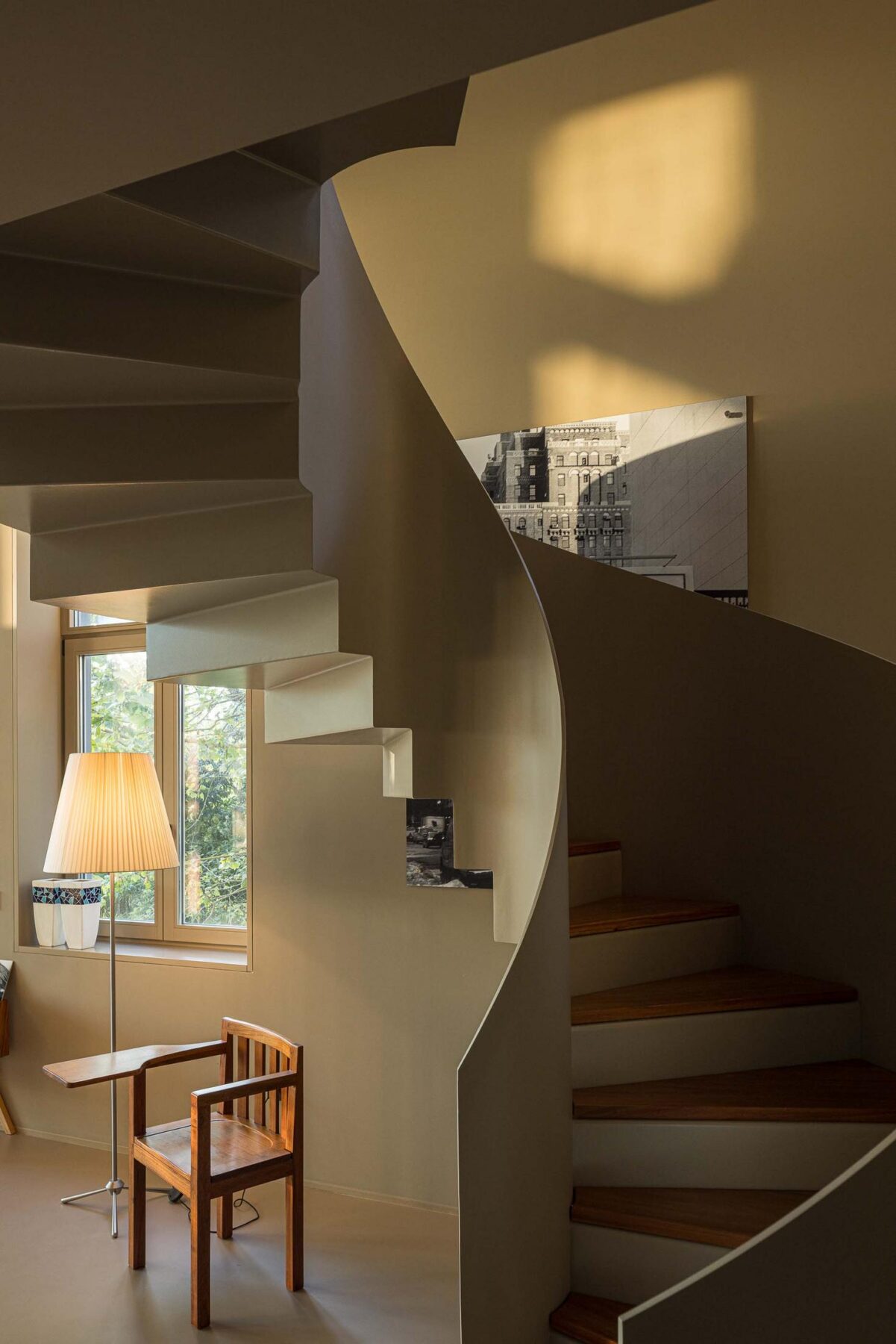 Escadas: Detalhe da escada em caracol com candeeiro e fotografias na parede. — Assembleia da Granja arquitetura Lousinha Arquitectos em Vila Nova de Gaia