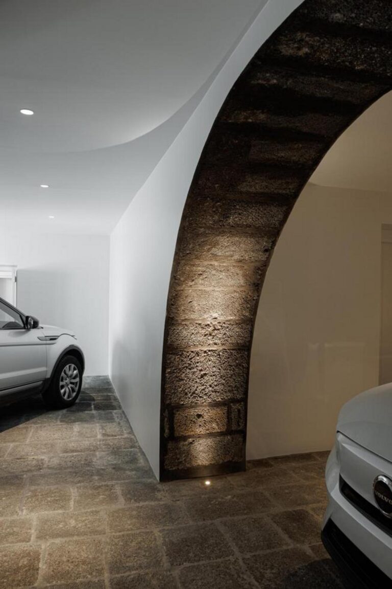 Candeeiro de design minimalista, suspenso sobre a mesa de jantar, complementando a iluminação natural e a estética contemporânea do espaço. — Casa T+A Açores . T+A . Azores House arquitectura Atelier d’arquitectura Lopes da Costa fotografia Ivo Tavares