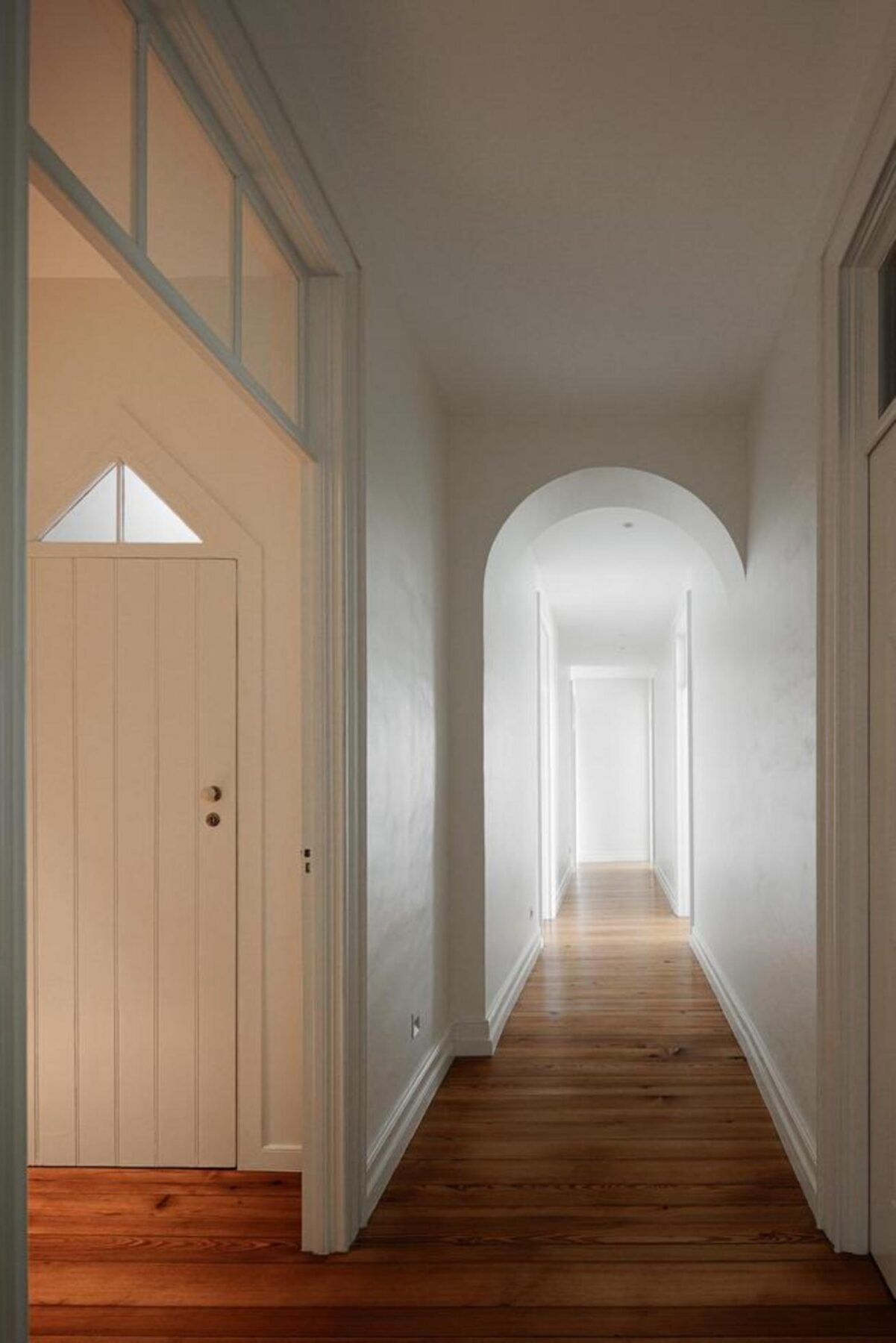 Fachada tardoz de reabilitação, com caixilharias contemporâneas em madeira escura e reboco claro, abrindo-se para o logradouro ajardinado. — Casa T+A Açores . T+A . Azores House arquitectura Atelier d’arquitectura Lopes da Costa fotografia Ivo Tavares