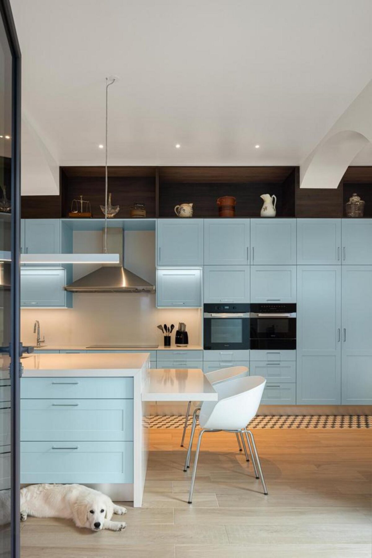 Canto de leitura com poltrona e candeeiro de pé, junto a um vão de janela, criando um espaço de conforto e introspecção na sala. — Casa T+A Açores . T+A . Azores House arquitectura Atelier d’arquitectura Lopes da Costa fotografia Ivo Tavares