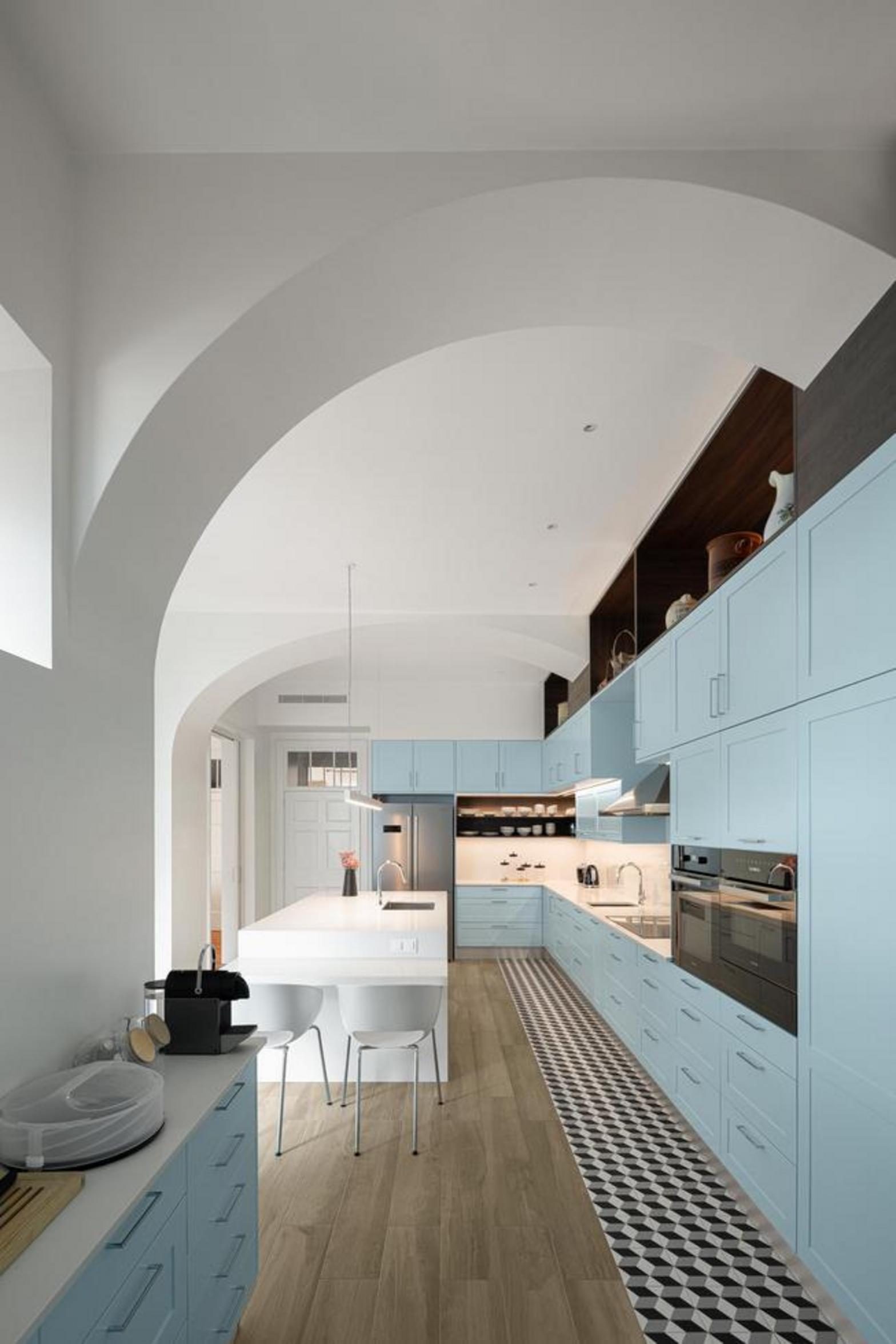 Corredor. Pavimento em madeira mel, paredes brancas. Vários vãos de porta em arco, criando profundidade e luz — Casa T+A Açores arquitectura Lopes da Costa fotografia Ivo Tavares