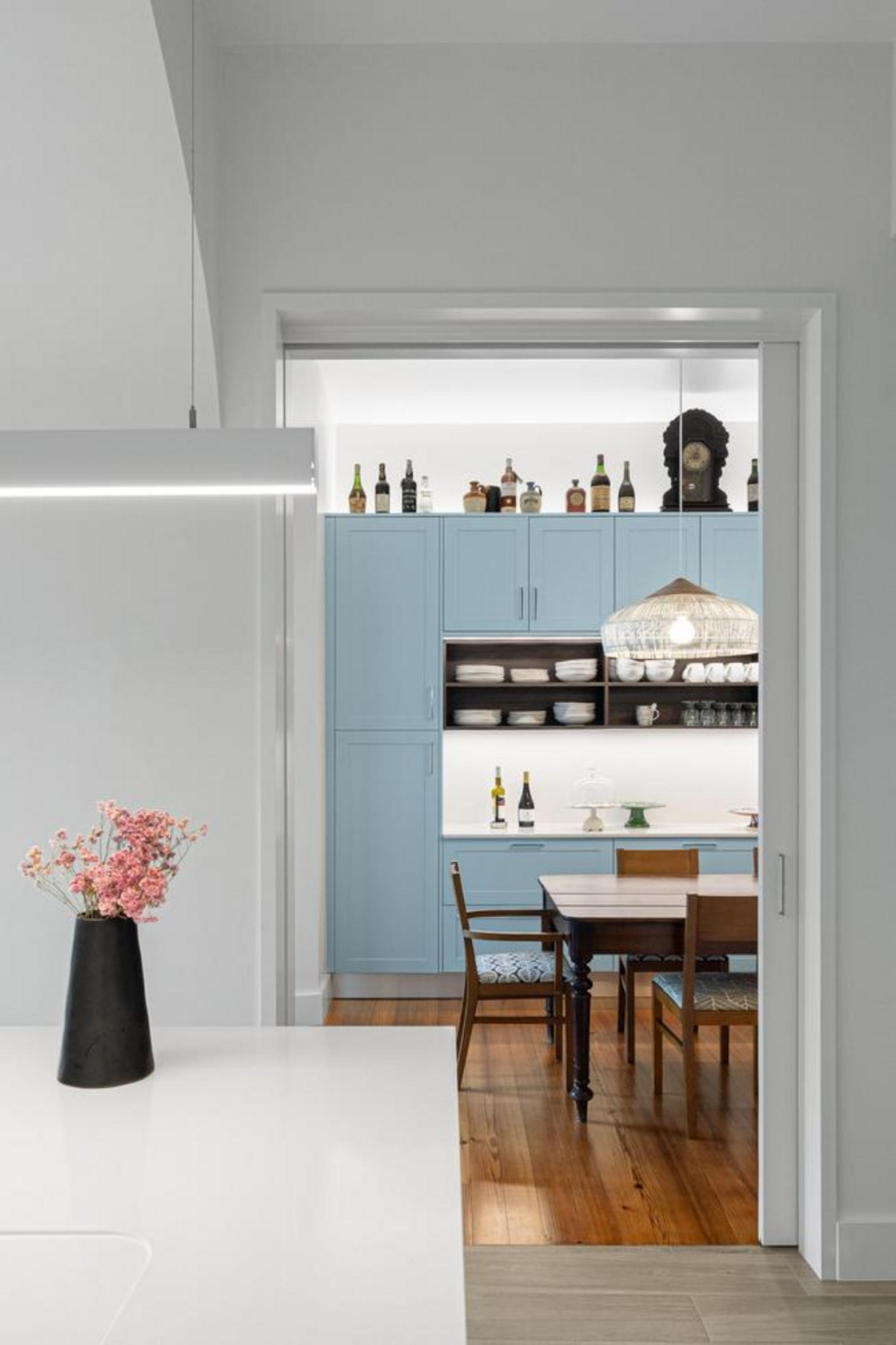 Interior. Pavimento em pedra cinzenta. Arcos de pedra rústica iluminados. Jardim interior com palmeira e escada de pedra — Casa T+A Açores arquitectura Lopes da Costa fotografia Ivo Tavares