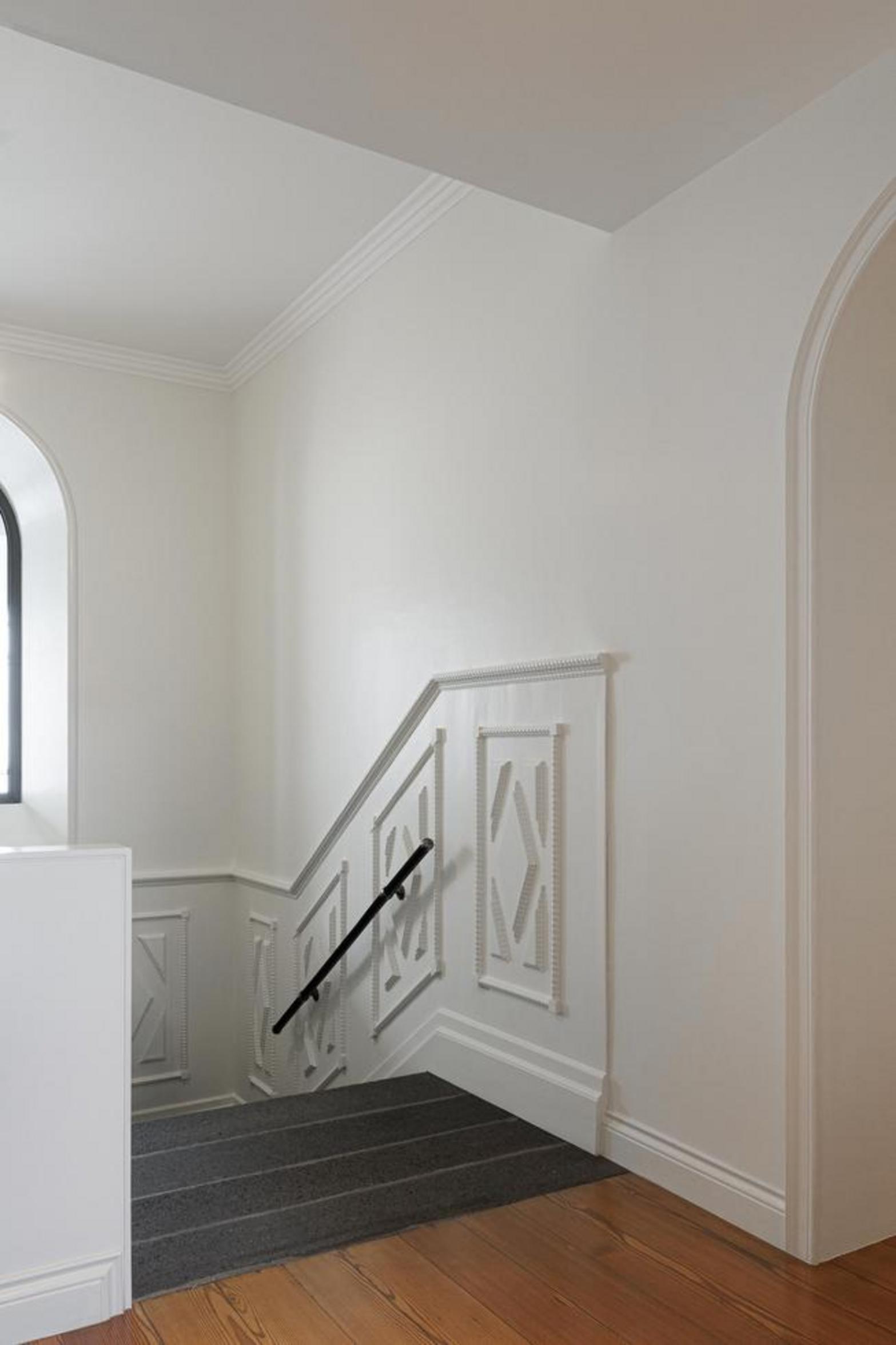 Escada. Detalhe de balaústres brancos torneados sobre degraus de pedra cinzenta. Parede branca com rodapé — Casa T+A Açores arquitectura Lopes da Costa fotografia Ivo Tavares