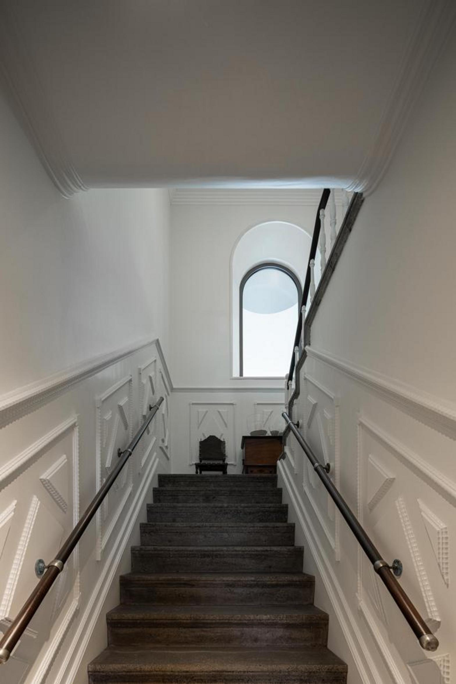 Escada. Degraus de pedra cinzenta. Corrimão de madeira escura com balaústres brancos. Paredes brancas com molduras — Casa T+A Açores arquitectura Lopes da Costa fotografia Ivo Tavares