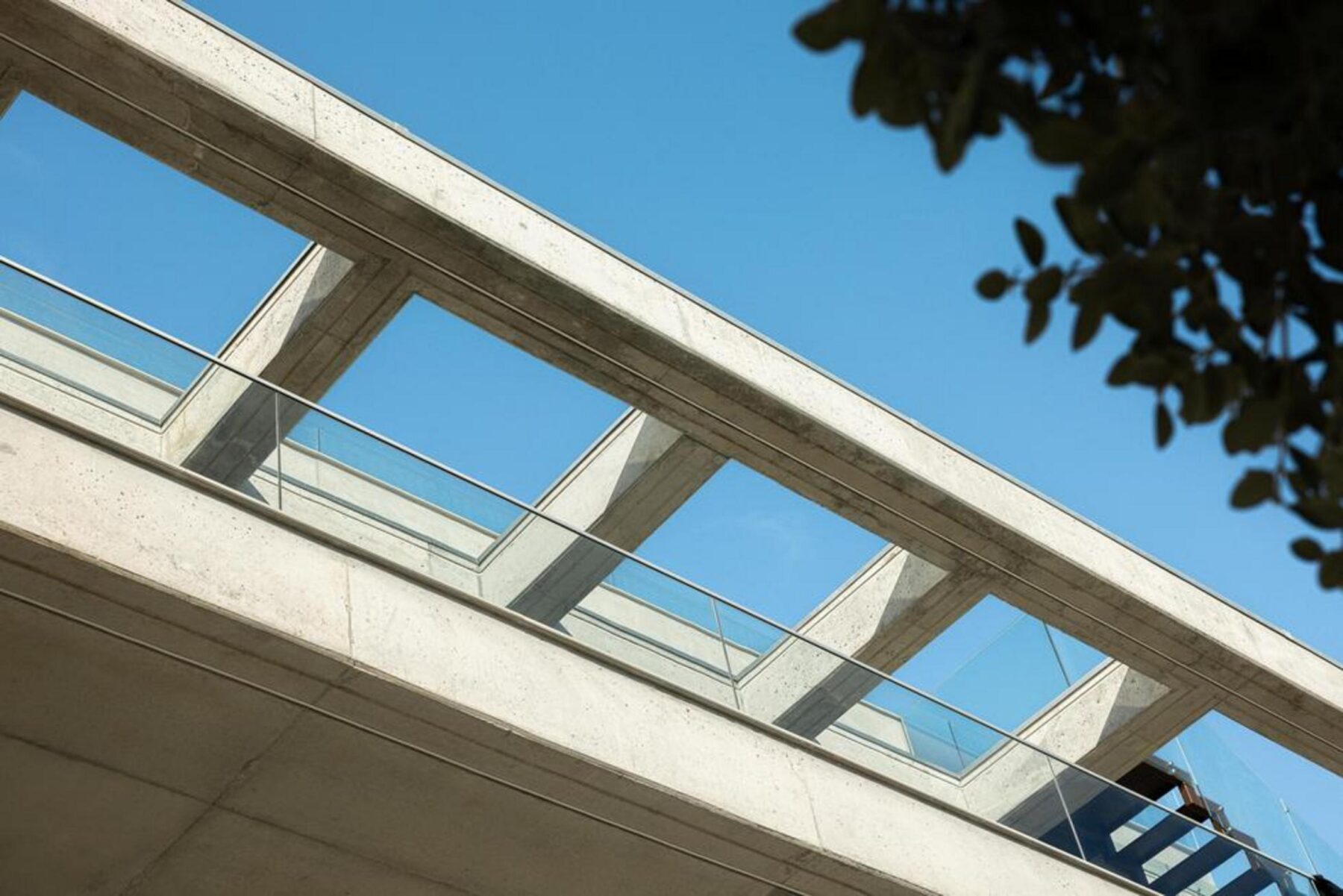 Cozinha aberta: Conceito de planta aberta, com bancada em pedra e armários minimalistas, integrando-se fluidamente na sala. — Edifício Scala-Mare arquitectura Atelier d’Arquitectura Lopes da Costa fotografia Ivo Tavares