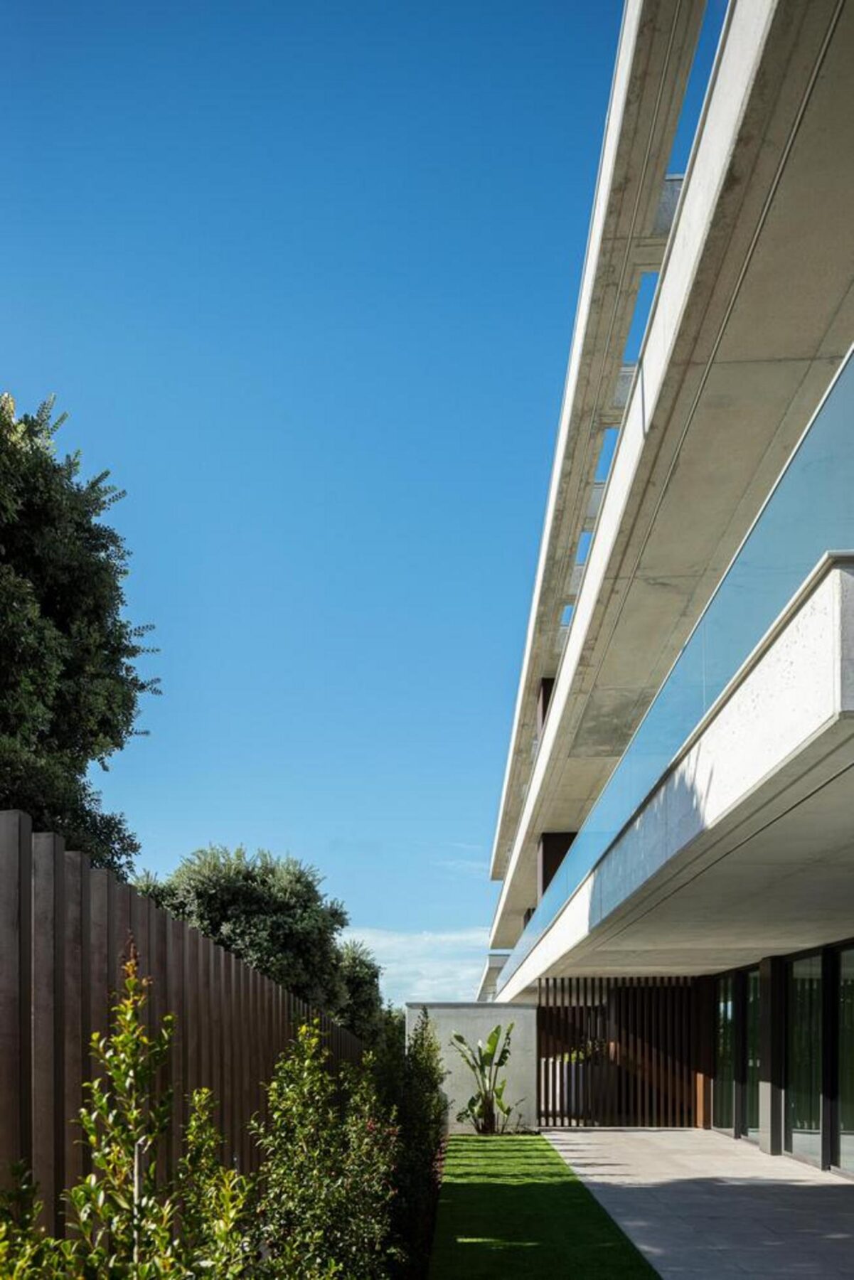 Casa de banho de serviço: Revestimento em cerâmica de grande formato, lavatório suspenso e espelho simples, funcionalidade e design. — Edifício Scala-Mare arquitectura Atelier d’Arquitectura Lopes da Costa fotografia Ivo Tavares