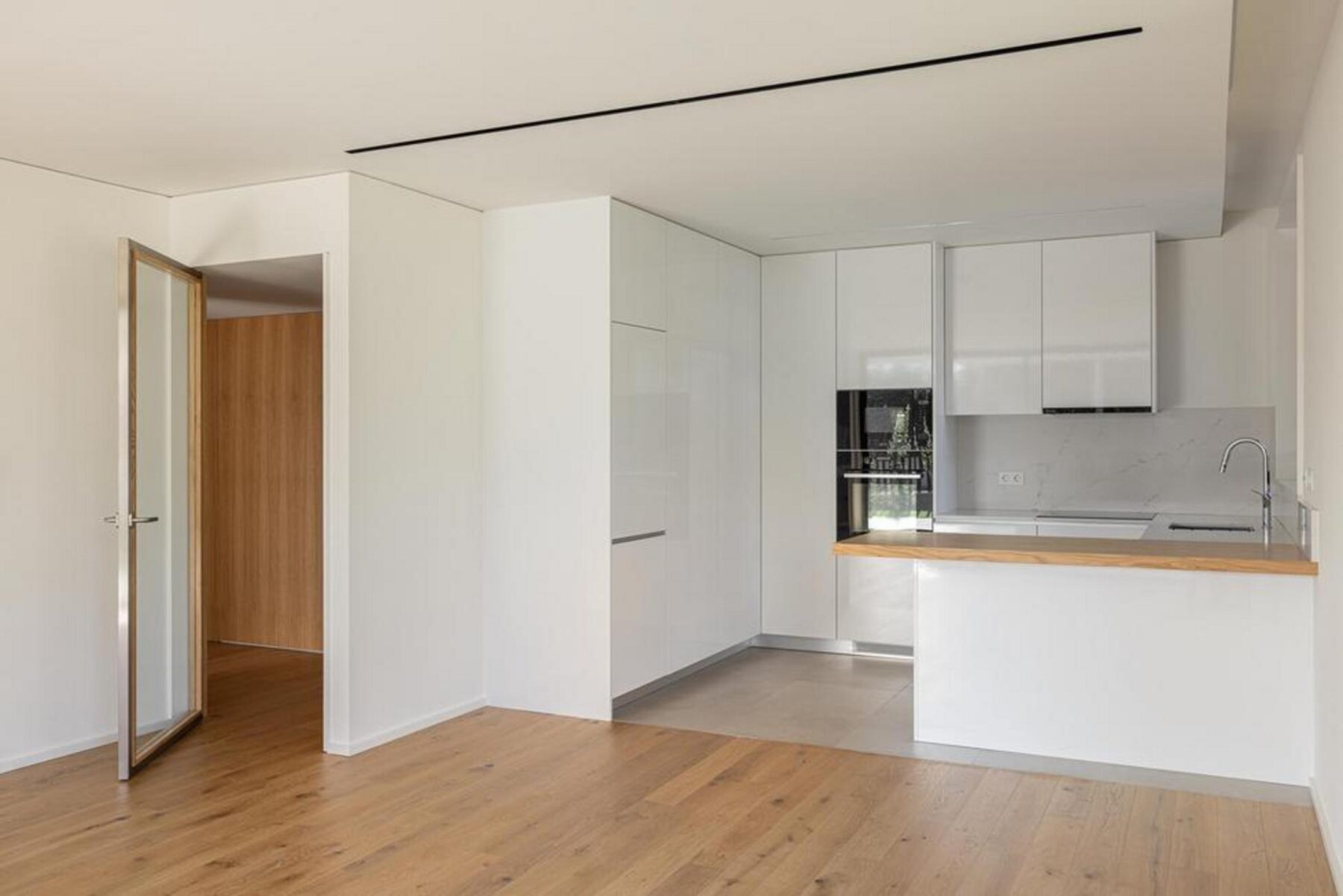 Corredor de acesso: Espaço interior com pavimento em madeira e paredes brancas, conduzindo aos quartos e áreas privadas. — Edifício Scala-Mare arquitectura Atelier d’Arquitectura Lopes da Costa fotografia Ivo Tavares