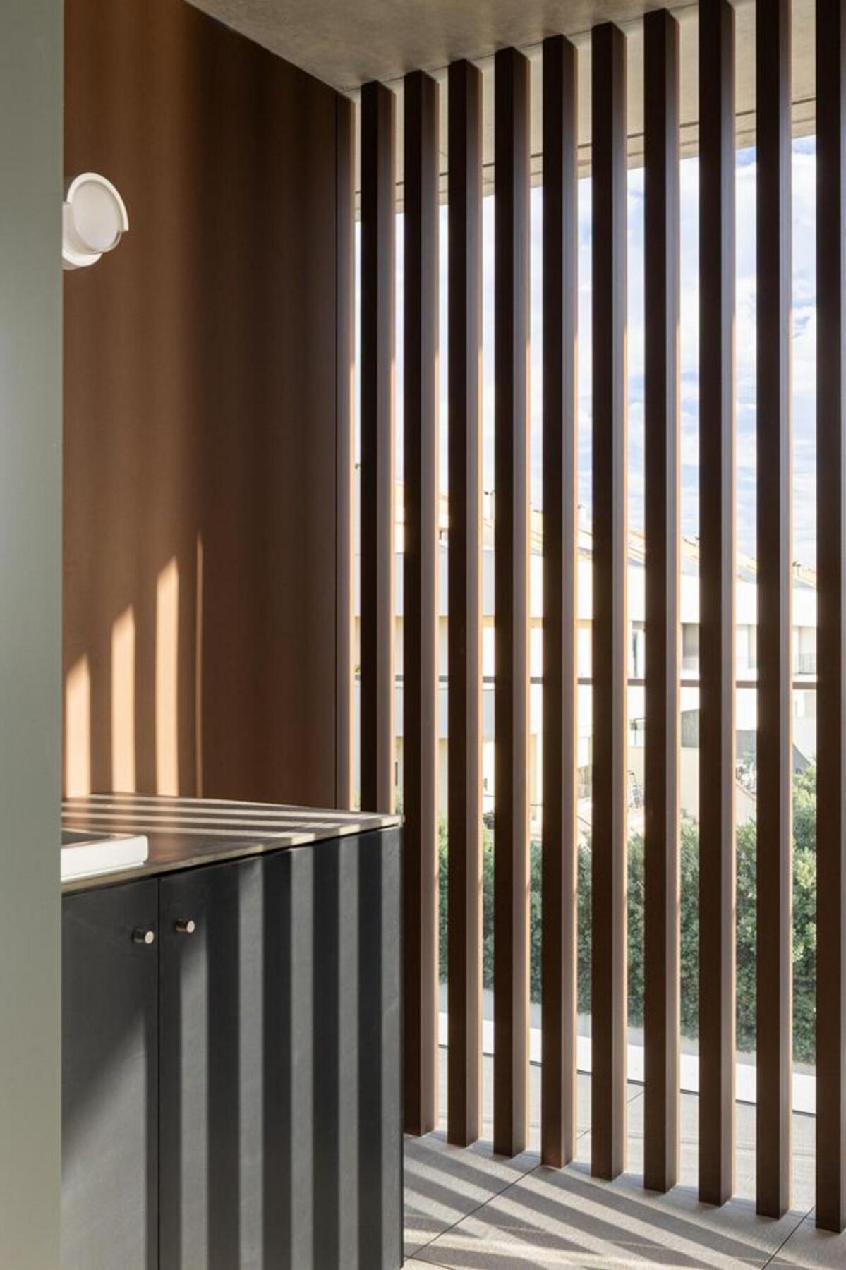 Pátio com vegetação: Área exterior privativa com plantas autóctones e pavimento em deck, proporcionando um refúgio verde. — Edifício Scala-Mare arquitectura Atelier d’Arquitectura Lopes da Costa fotografia Ivo Tavares