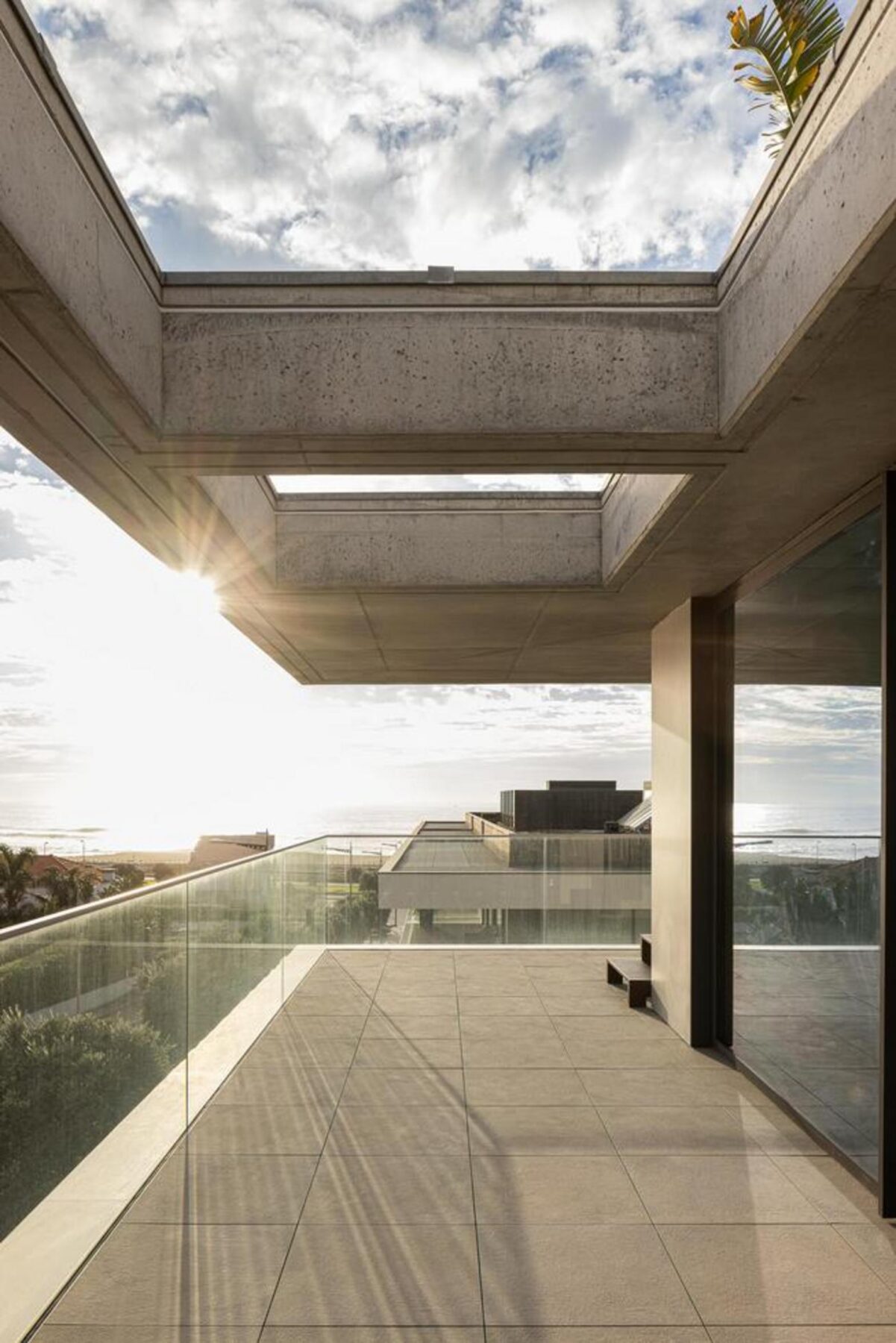 Varanda ampla: Espaço exterior generoso com pavimento em deck de madeira, mobiliário de lazer e vista deslumbrante para o mar. — Edifício Scala-Mare arquitectura Atelier d’Arquitectura Lopes da Costa fotografia Ivo Tavares