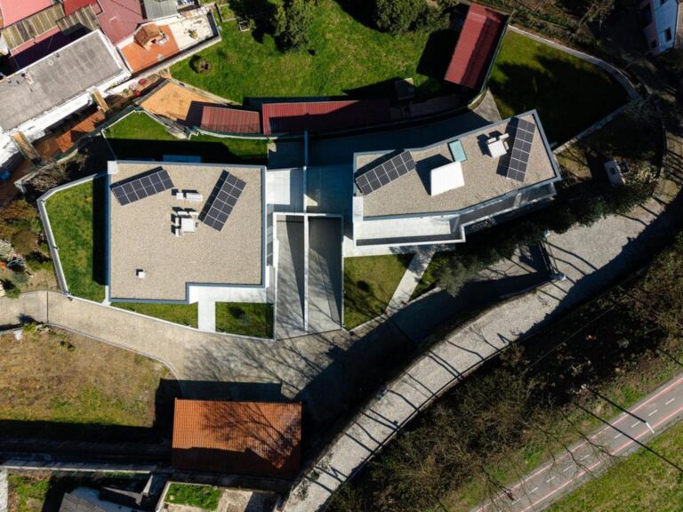 Quarto infantil com mobiliário simples e cores claras, beneficiando de luz natural abundante e vista para o exterior. — Duas casas em Guimarães arquitectura felixARQS – Daniel Félix Arquitectos fotografia Ivo Tavares
