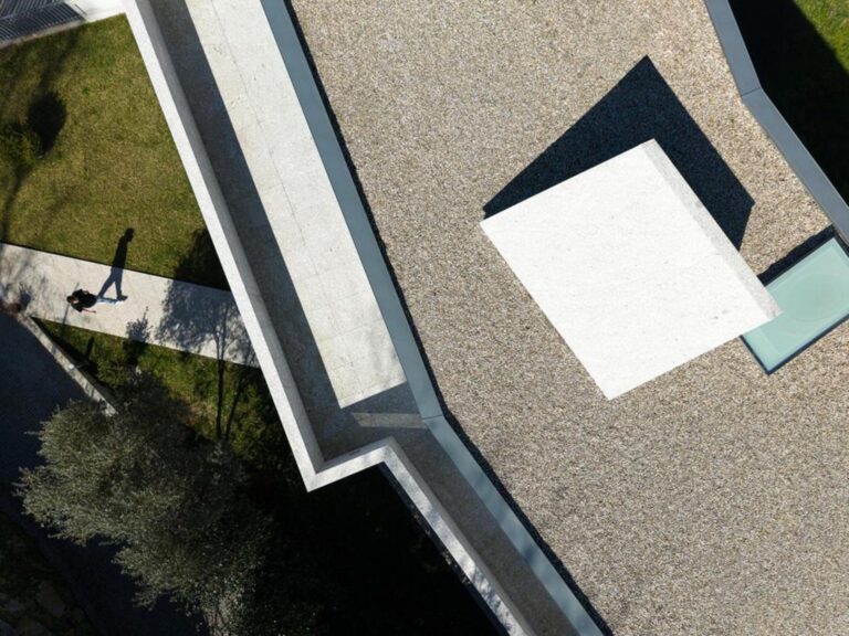 Corredor de circulação com luz natural filtrada, paredes brancas e pavimento em madeira, criando um percurso fluido. — Duas casas em Guimarães arquitectura felixARQS – Daniel Félix Arquitectos fotografia Ivo Tavares