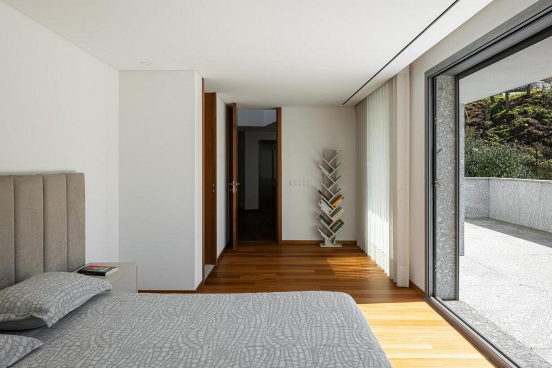 Sala de jantar com mesa de madeira e cadeiras de design, integrada num espaço fluido com a cozinha e a sala de estar. — Duas casas em Guimarães arquitectura felixARQS – Daniel Félix Arquitectos fotografia Ivo Tavares