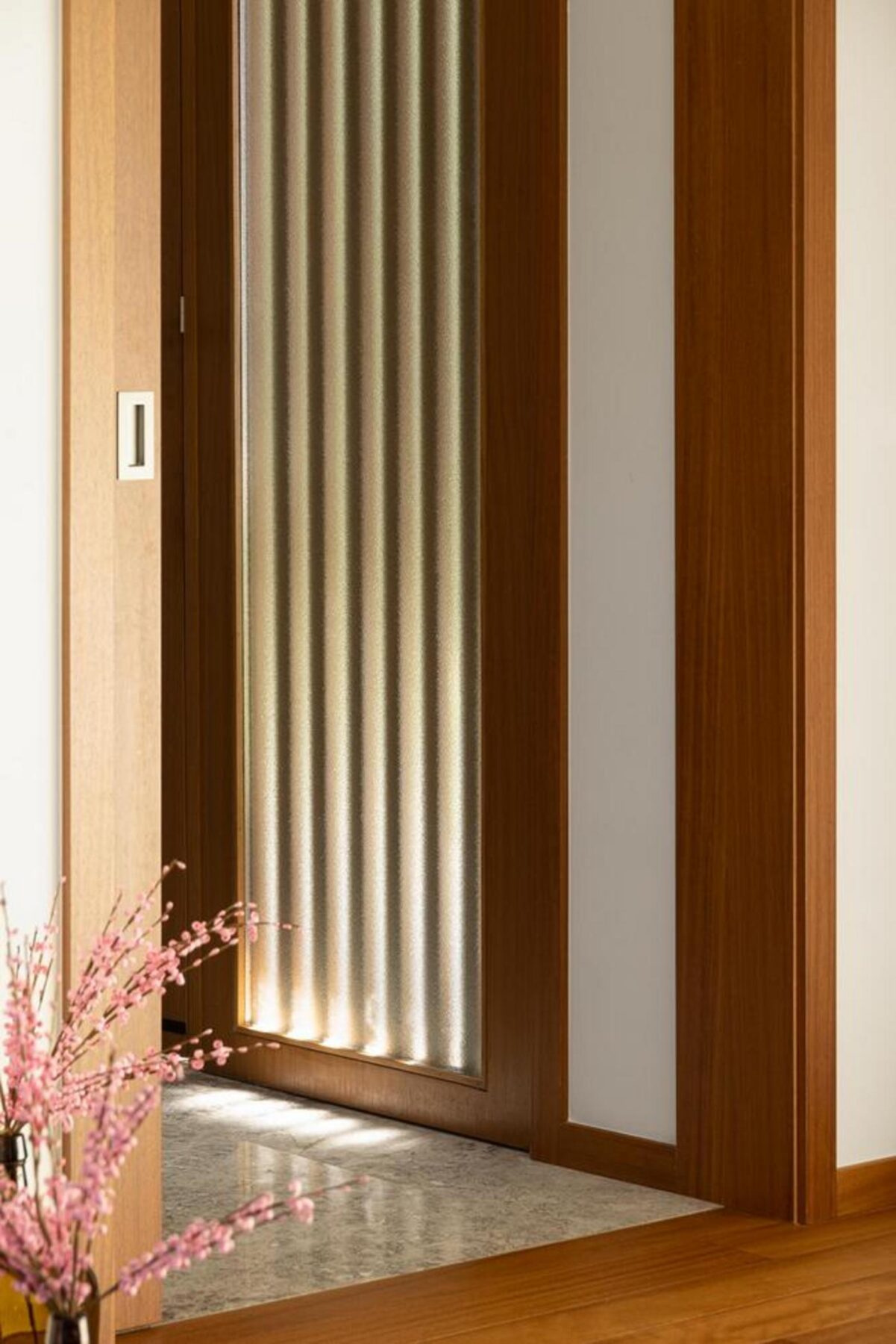 Varanda em consola, com pavimento em pedra e guarda-corpos de vidro, oferecendo um espaço exterior elevado e protegido. — Duas casas em Guimarães arquitectura felixARQS – Daniel Félix Arquitectos fotografia Ivo Tavares