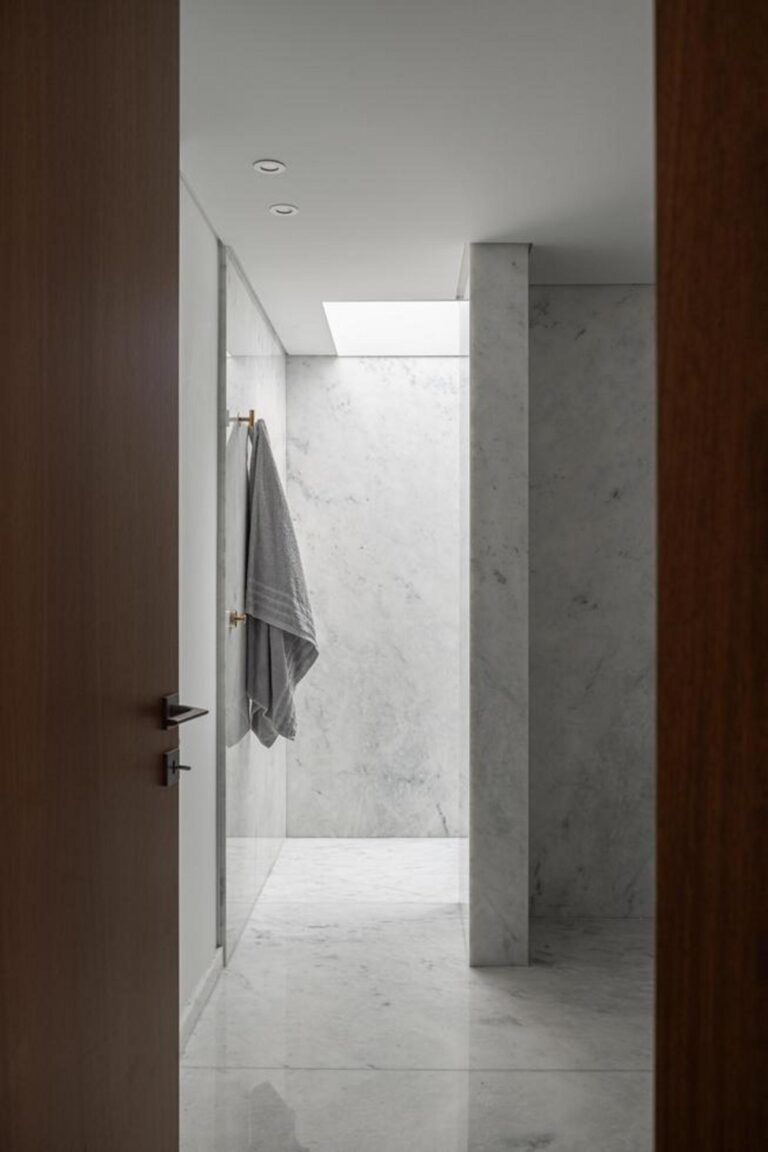 Interior da sala de estar, com pavimento em madeira de carvalho e paredes brancas, banhada por luz natural através de grandes vãos envidraçados. — Duas casas em Guimarães arquitectura felixARQS – Daniel Félix Arquitectos fotografia Ivo Tavares