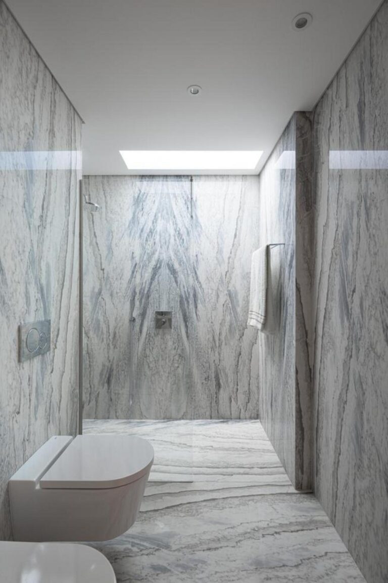 Hall de entrada com pé-direito duplo, paredes brancas e um candeeiro suspenso, criando uma sensação de amplitude. — Duas casas em Guimarães arquitectura felixARQS – Daniel Félix Arquitectos fotografia Ivo Tavares