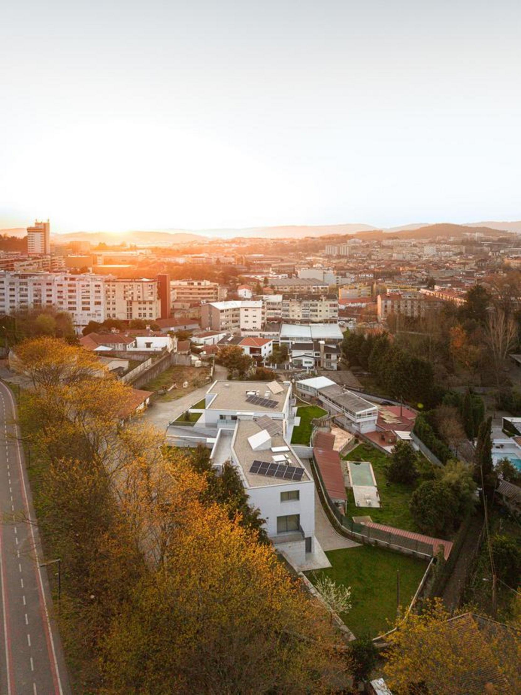 Vista aérea do complexo de moradias. Coberturas planas com painéis solares e áreas verdes, integrando-se na paisagem urbana envolvente — Duas Casas em Guimarães arquitectura Félix Arquitectos fotografia Ivo Tavares