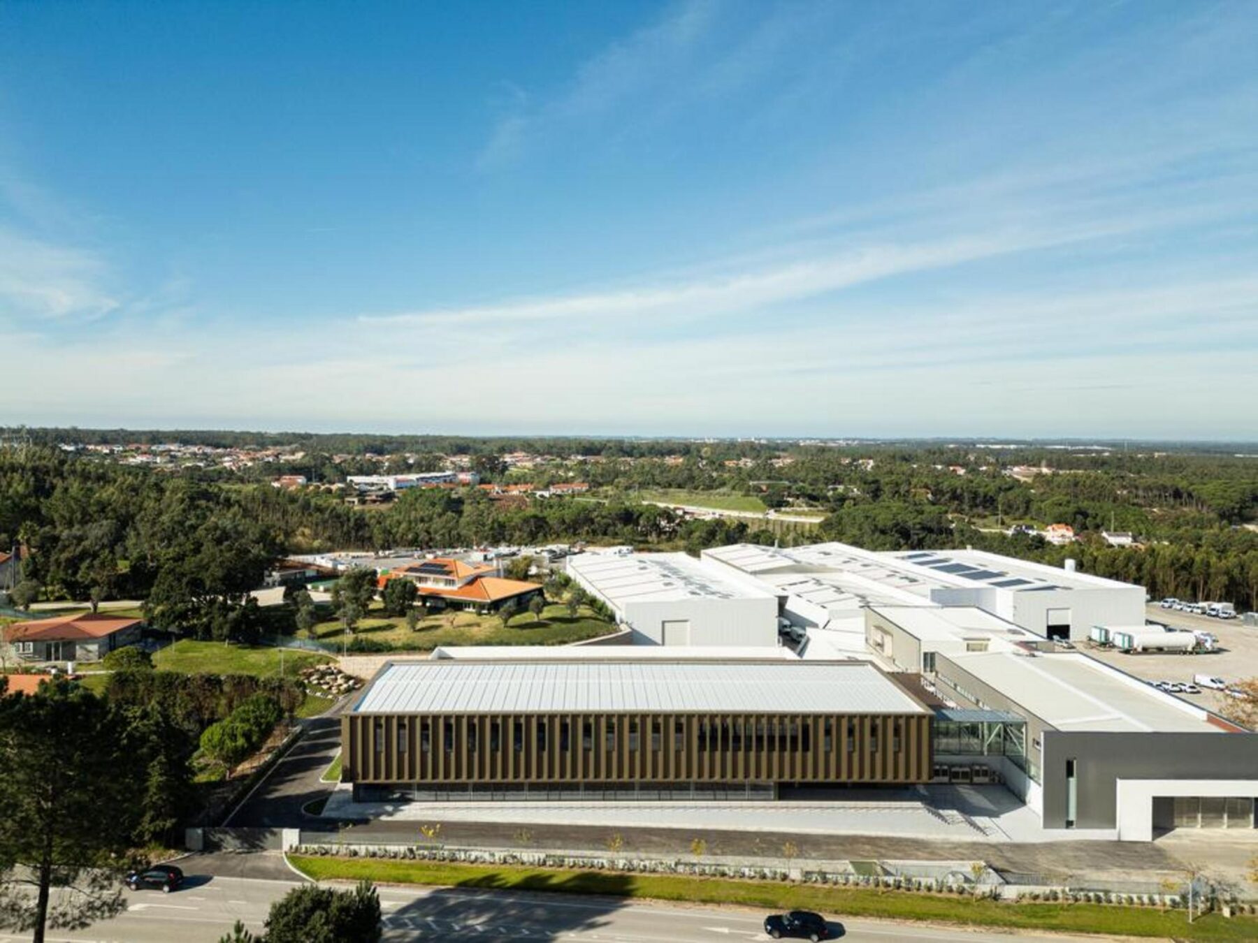 Vista exterior do novo volume administrativo, destacando a sua implantação paralela ao arruamento e a relação com o edifício existente. — EDIFÍCIO-SEDE PRF arquitectura Impare Arquitectura fotografia Ivo Tavares