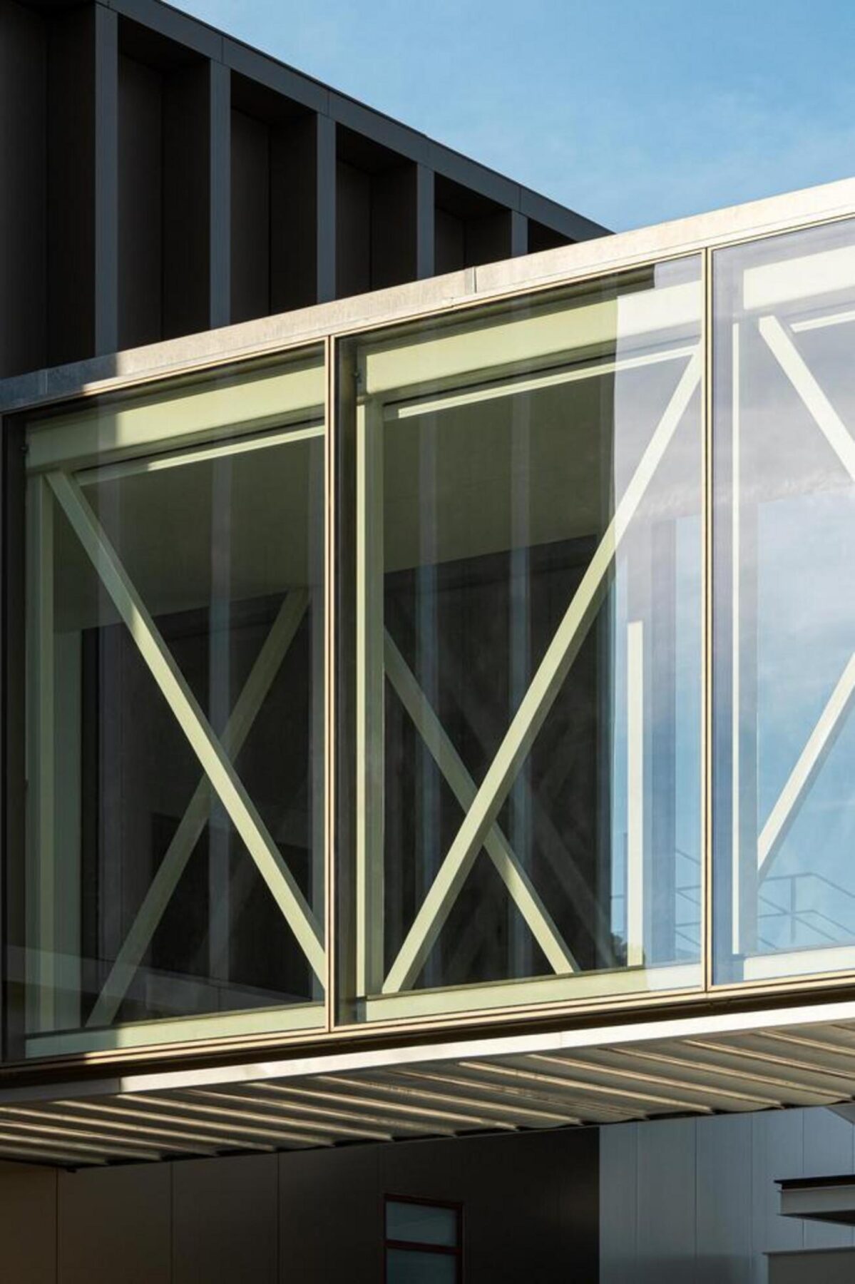 Área de receção no piso de entrada, com mobiliário de design e um balcão em betão, enquadrada pela amplitude do pé-direito duplo. — EDIFÍCIO-SEDE PRF arquitectura Impare Arquitectura fotografia Ivo Tavares