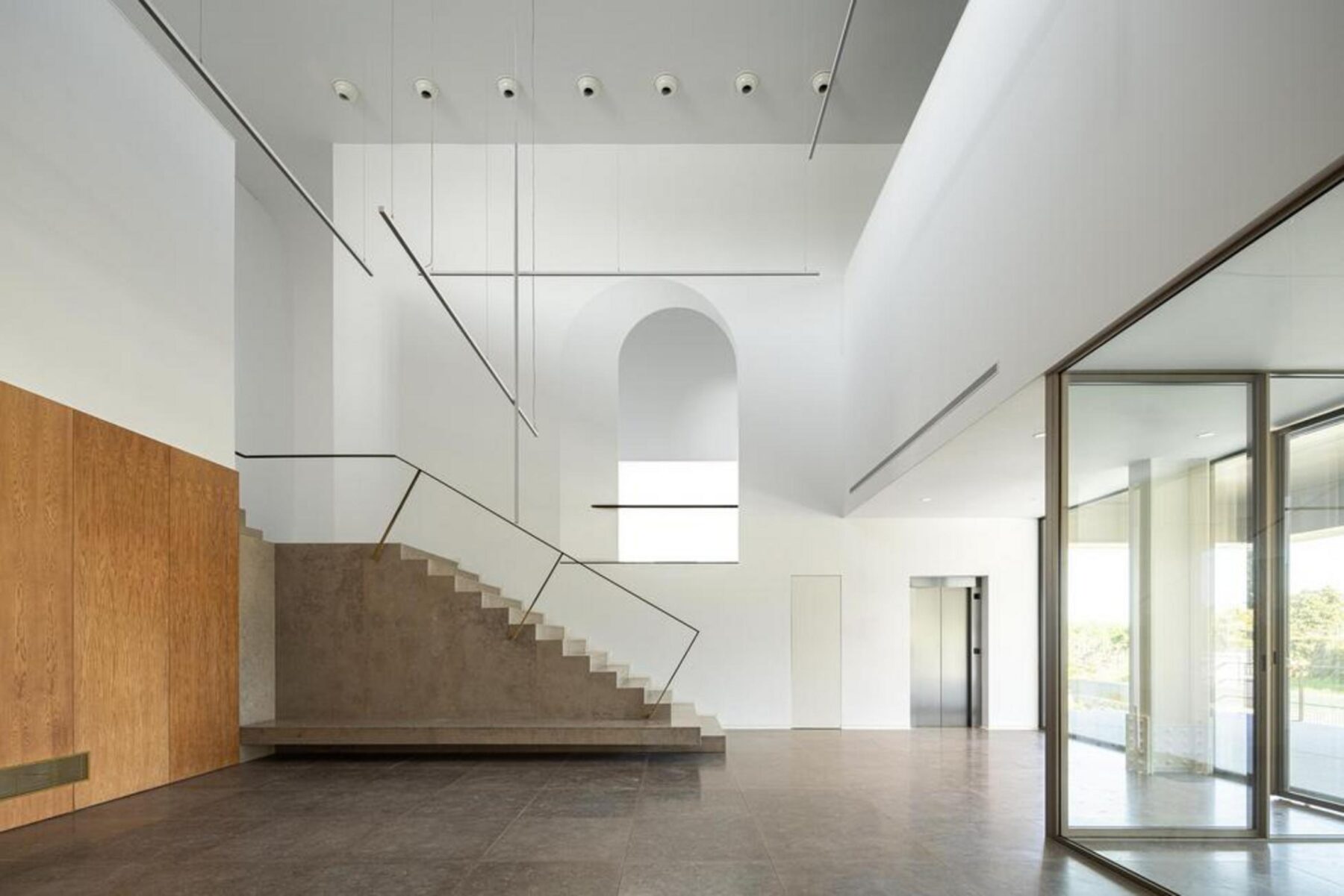 Vista do espaço de pé-direito duplo, que estabelece a ligação visual e funcional entre o piso de entrada e o piso superior administrativo. — EDIFÍCIO-SEDE PRF arquitectura Impare Arquitectura fotografia Ivo Tavares
